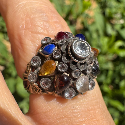 14K gold ring set with a central transparent gemstone surrounded by a vibrant mosaic of colorful gemstones -set in an ornate, handcrafted design