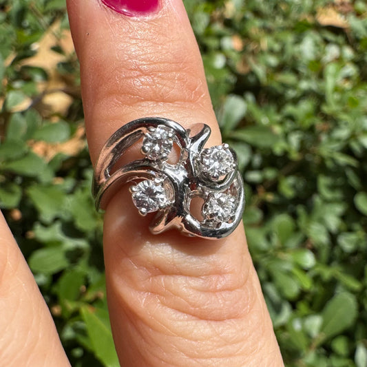 14K gold ring set with four brilliant-cut Diamonds, arranged in an elegant flowing design