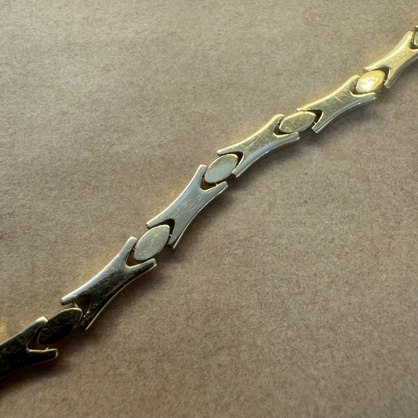 14K gold bracelet featuring a bold geometric design with X-shaped