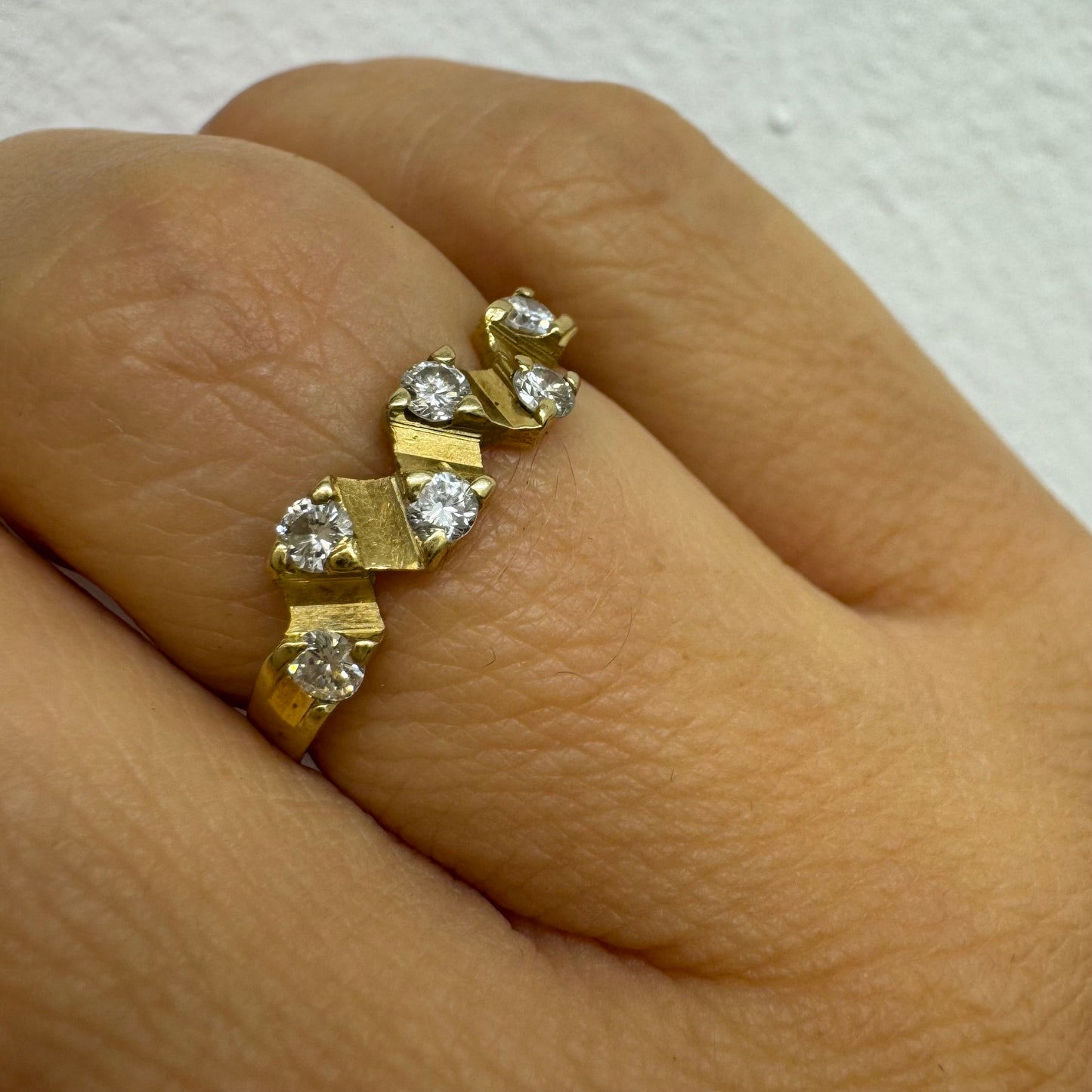 טבעת זהב 14 קראט בעיצוב זיגזג, משובצת יהלומים נוצצים. תכשיט וינטג’ עדין עם טאץ’ גאומטרי ייחודי.