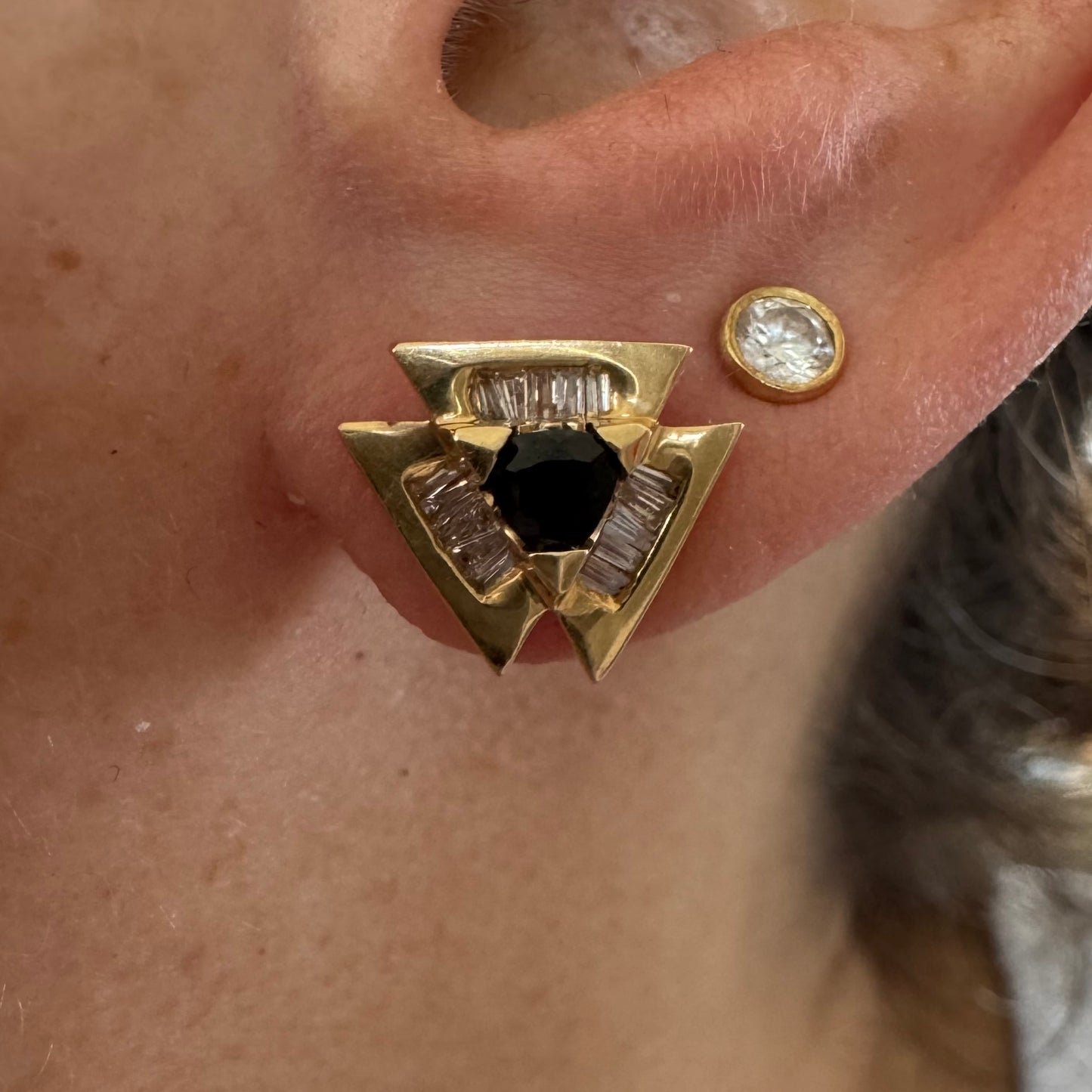 14K gold geometric stud earrings set with a Sapphire stone, surrounded by baguette Diamonds.