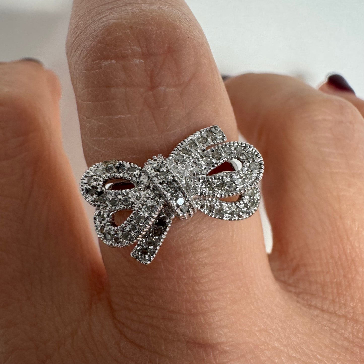 טבעת זהב לבן 14 קראט מעוצבת בצורת פפיון ומשובצת יהלומים בשיבוץ פאבה צפוף.