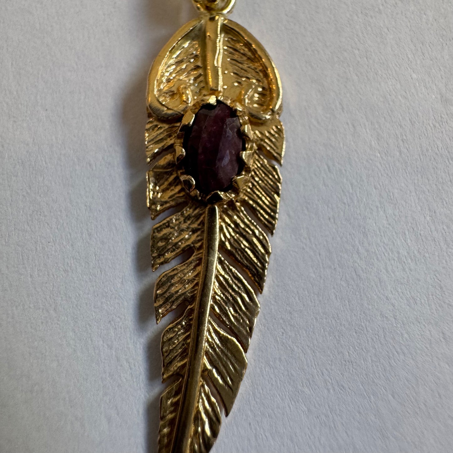 14K gold feather pendant set with a unique Ruby at its center.