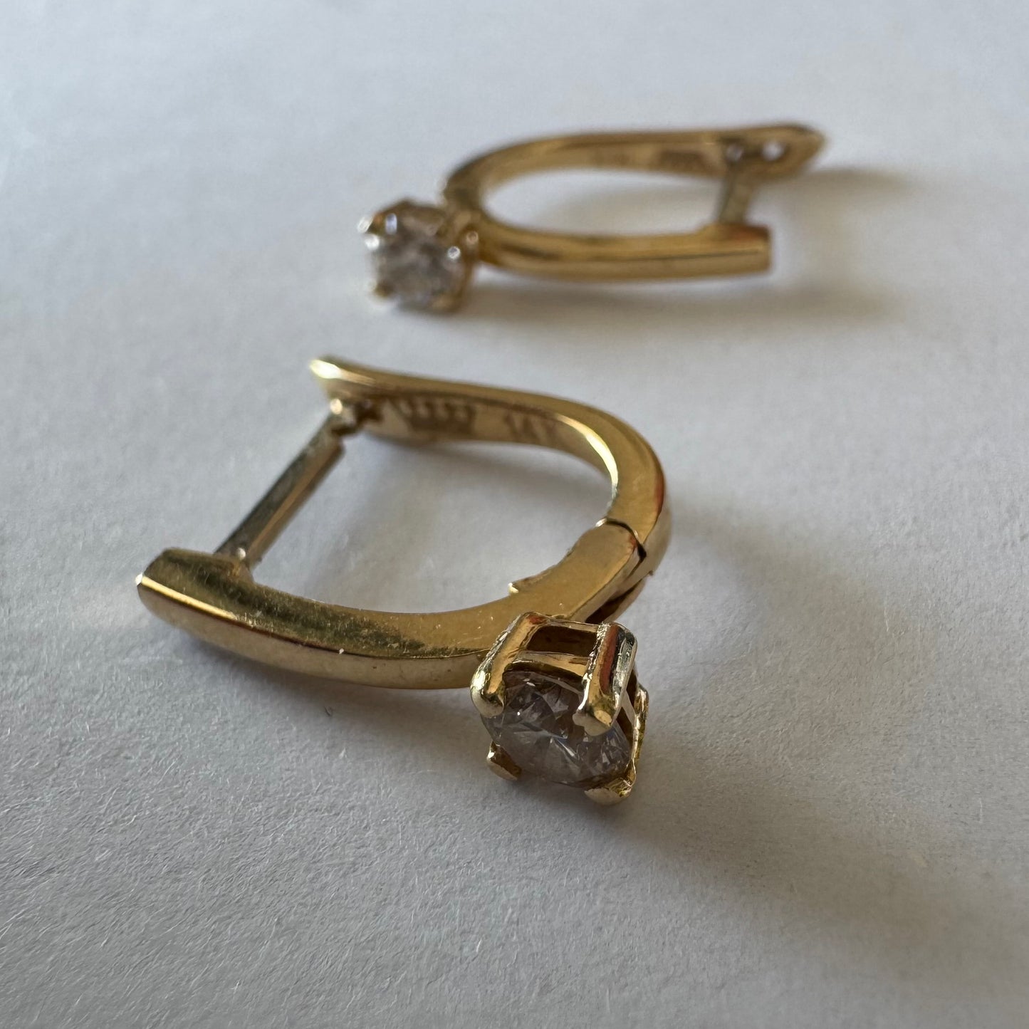 14K gold earrings set with round brilliant-cut Diamonds.