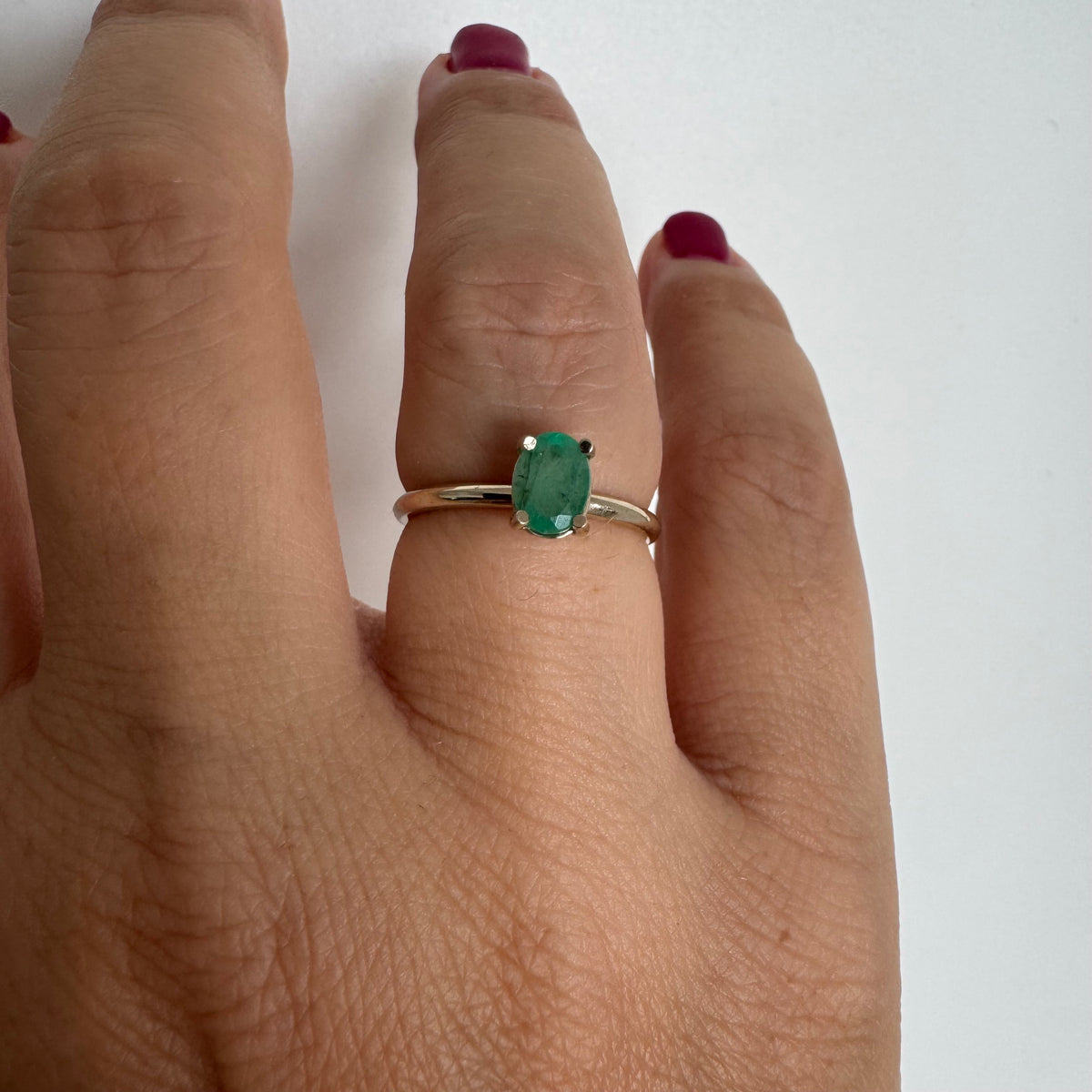 14K gold ring set with an oval-cut Emerald
