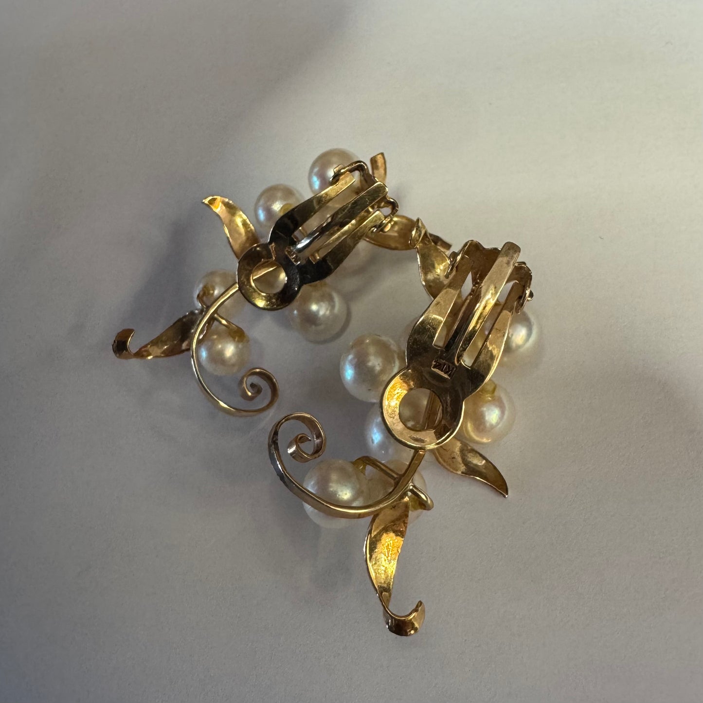 עגילי קליפס זהב 14 קראט, משובצים אשכול פנינים בגווני לבן-קרם.