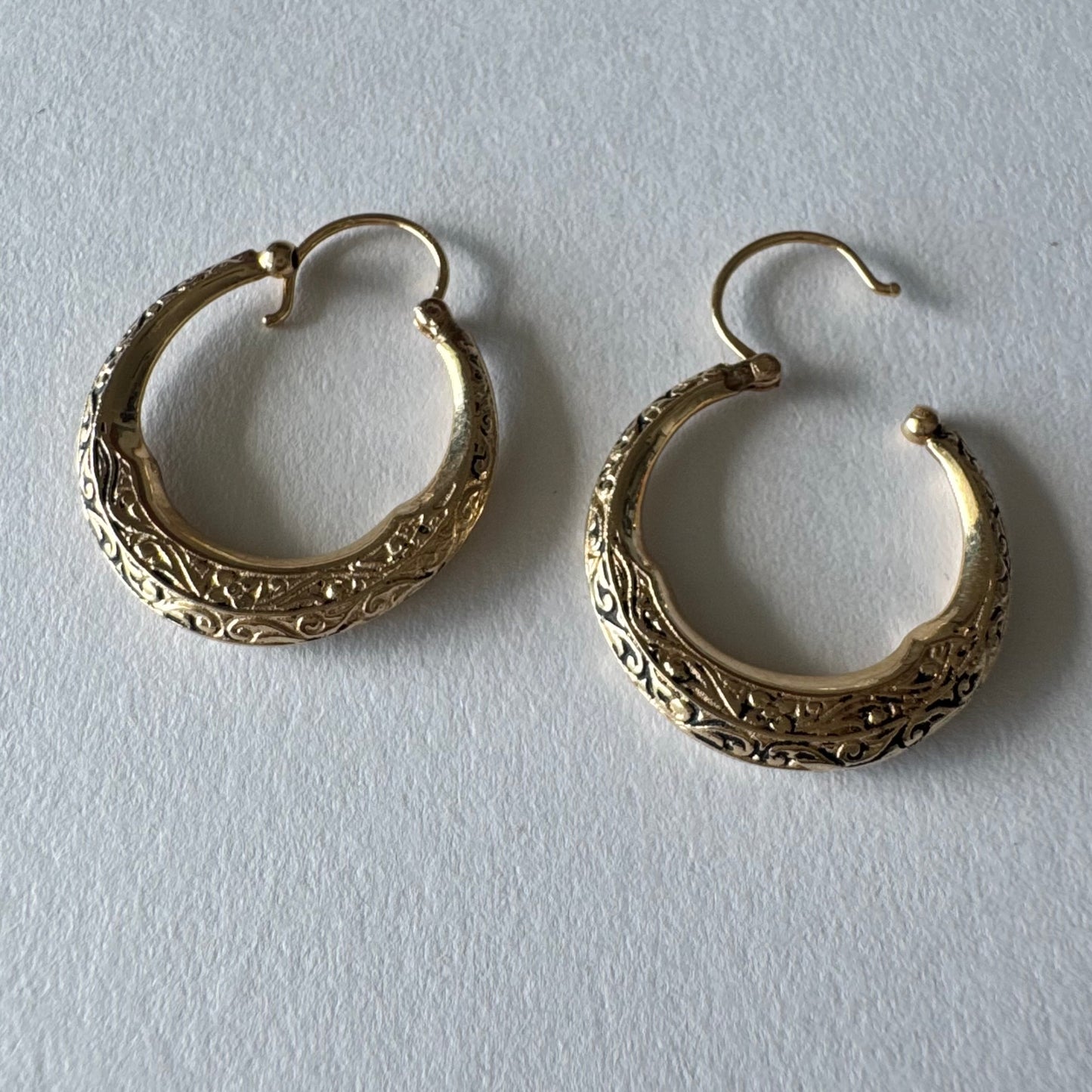 14K gold hoop earrings featuring an intricate openwork design and beautifully detailed engraving