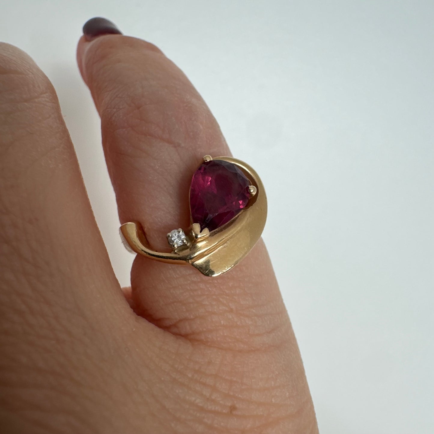 14K gold sculptural open ring set with a pear-cut pink Tourmaline, accented by a small Diamond.