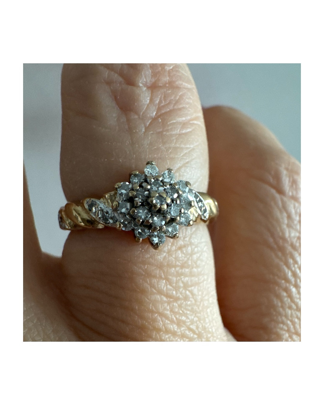 טבעת זהב צהוב 9 קראט משובצת יהלומים בעיצוב פרח עדין.