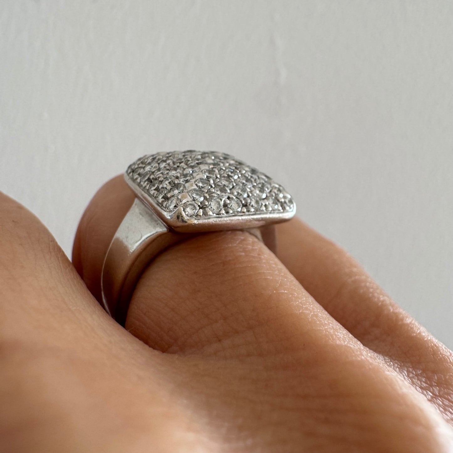 טבעת זהב לבן 18 קראט עם חלק עליון רחב בצורת ריבוע המשובץ כולו ביהלומים מנצנצים, ליצירת מראה יוקרתי ונוצץ.