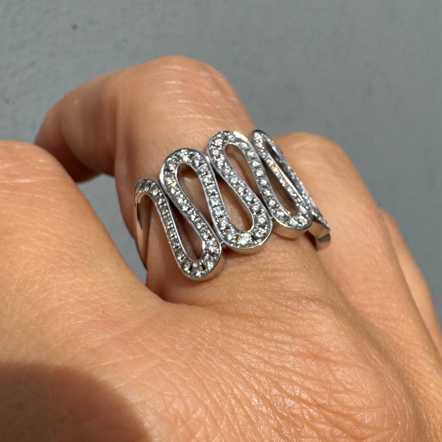 טבעת זהב לבן 14 קראט משובצת יהלומים נוצצים בעיצוב גל מתפתל