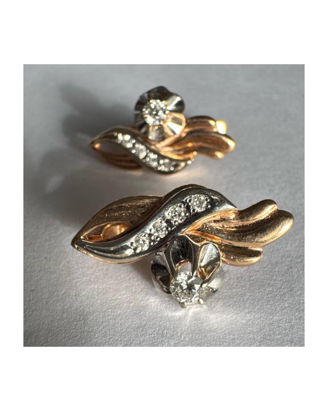 עגילי זהב 14 קראט בעיצוב מתעגל ואלגנטי המשובצים יהלומים נוצצים .