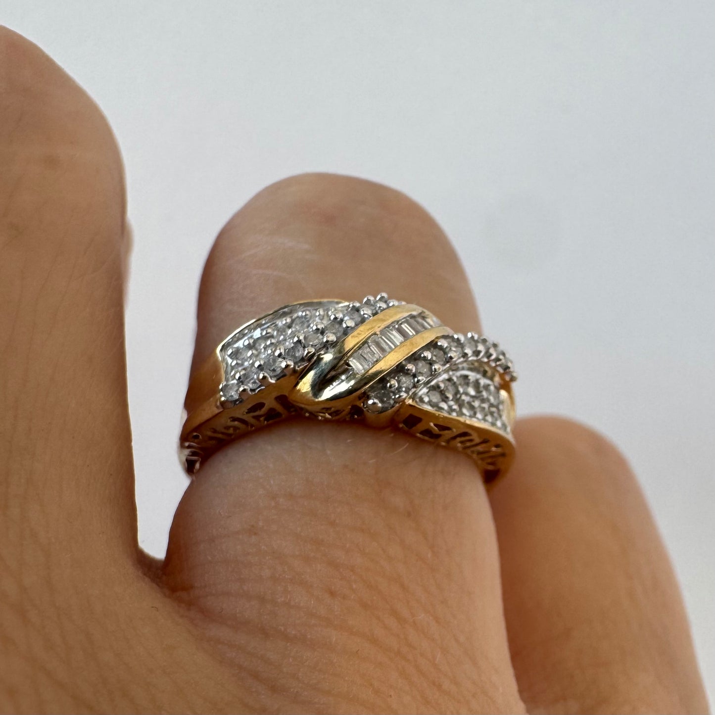 10K gold ring set with round-cut Diamonds and a central row of baguette Diamonds.