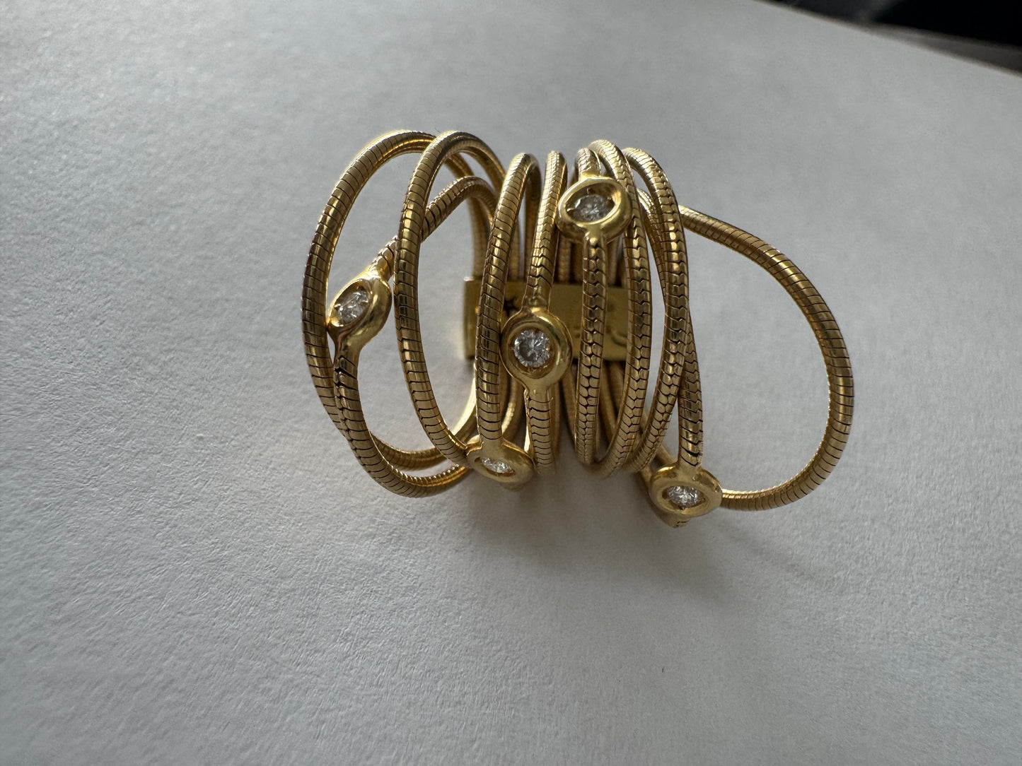 טבעת זהב צהוב 18 קראט של המותג H. Stern משובצת יהלומים בעיצוב רב־ליפופים אלגנטי 