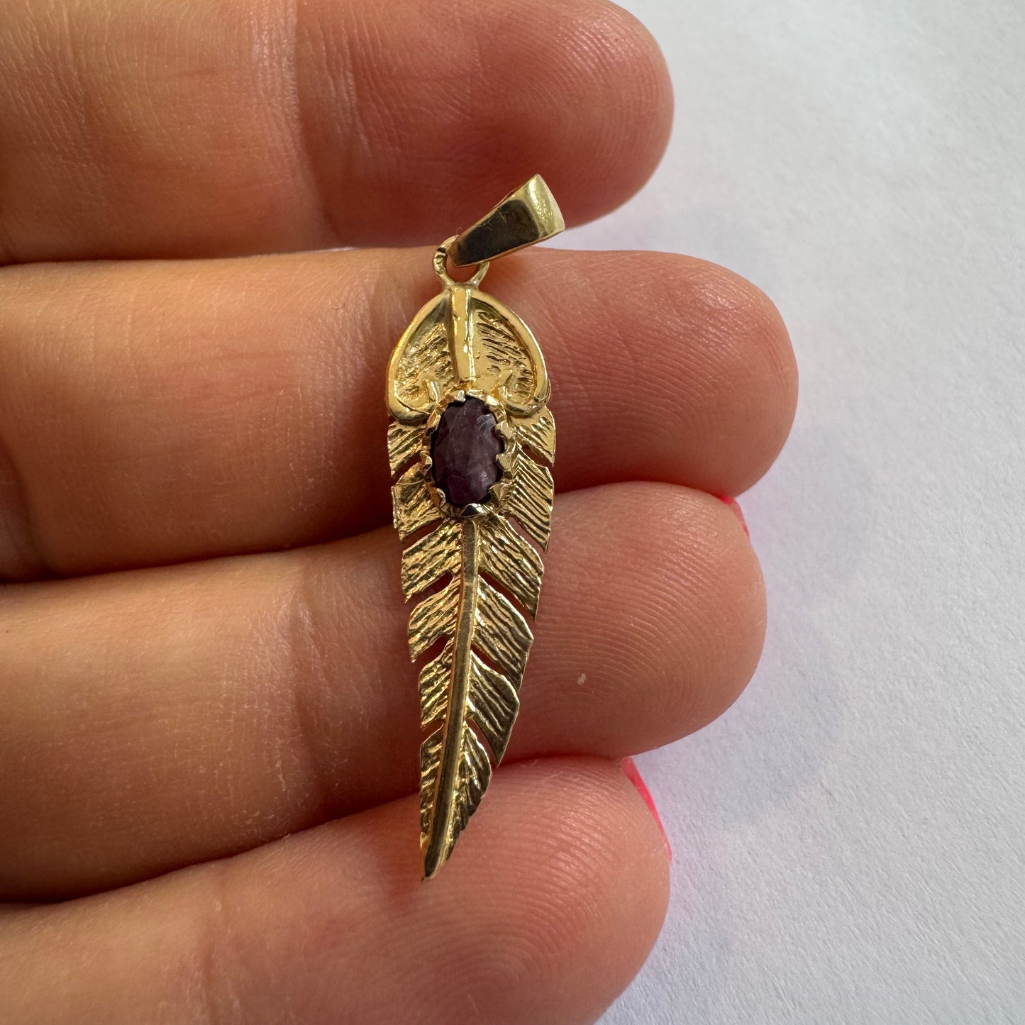 14K gold feather pendant set with a unique Ruby at its center.