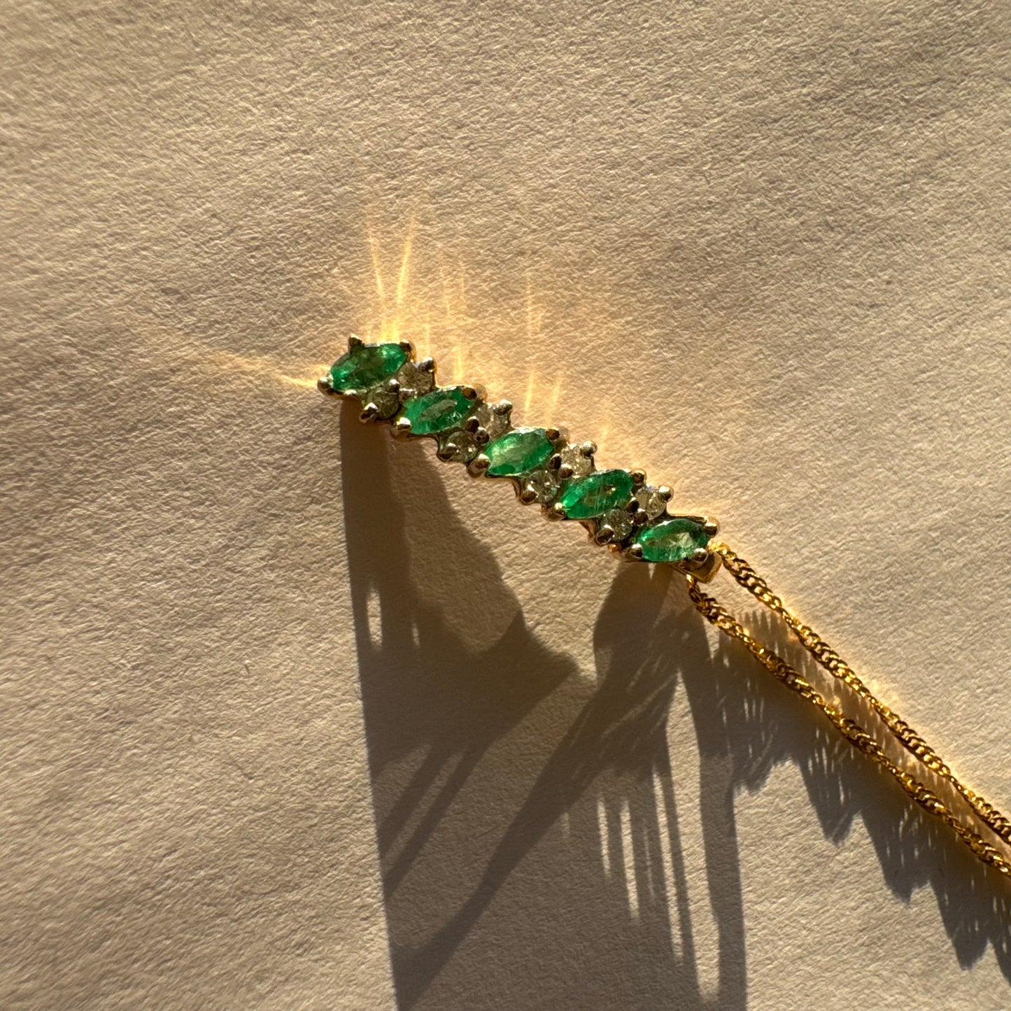 תליון זהב 14 קראט משובץ אמרלדים בחיתוך מרקיזה ויהלומים נוצצים. 