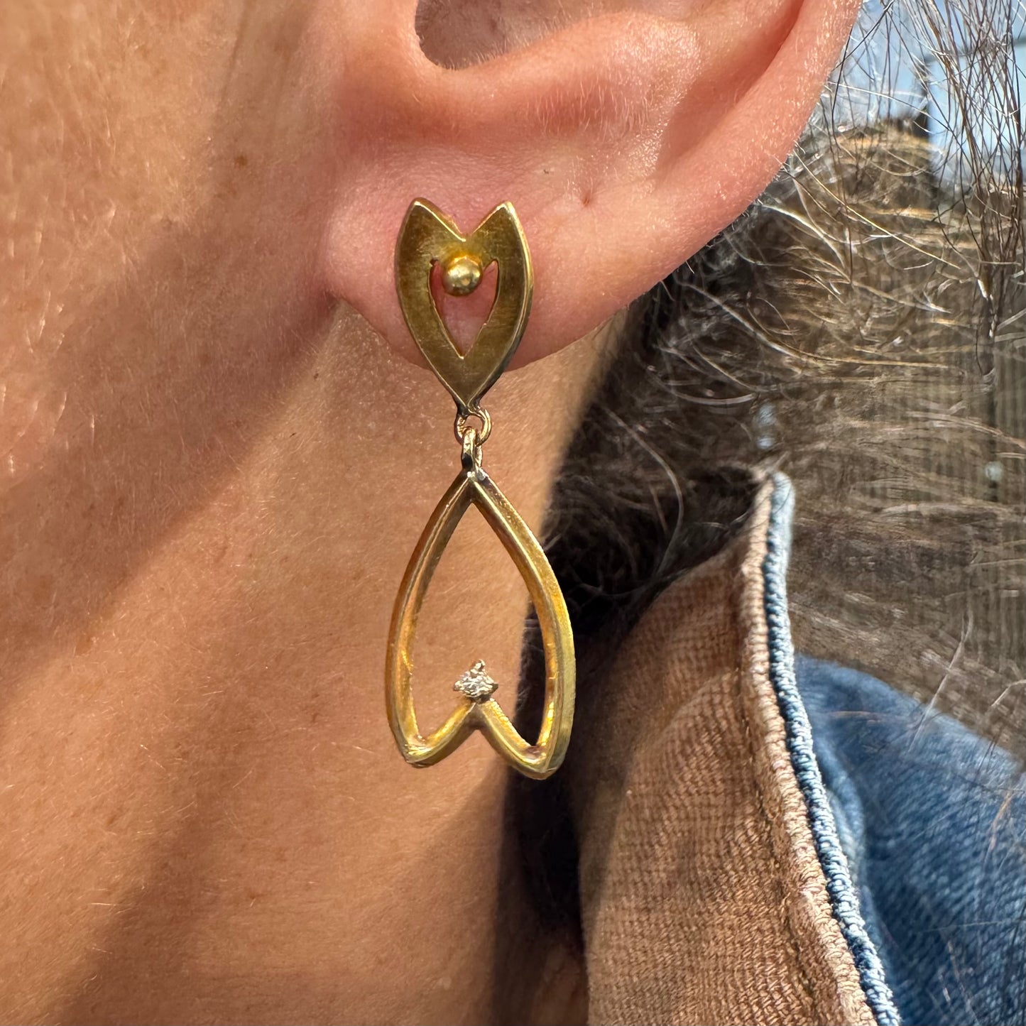 עגילי זהב צהוב 18 קראט בעיצוב עדין ומיוחד בצורת לב, עם יהלום קטן שמוסיף נצנוץ מדויק