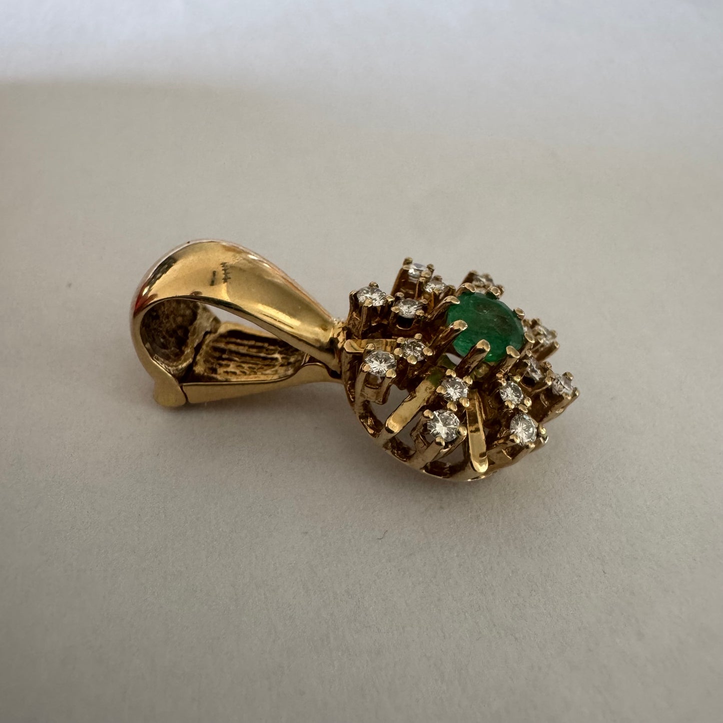14K gold pendant centered with a Emerald and surrounded by a halo of sparkling Diamonds