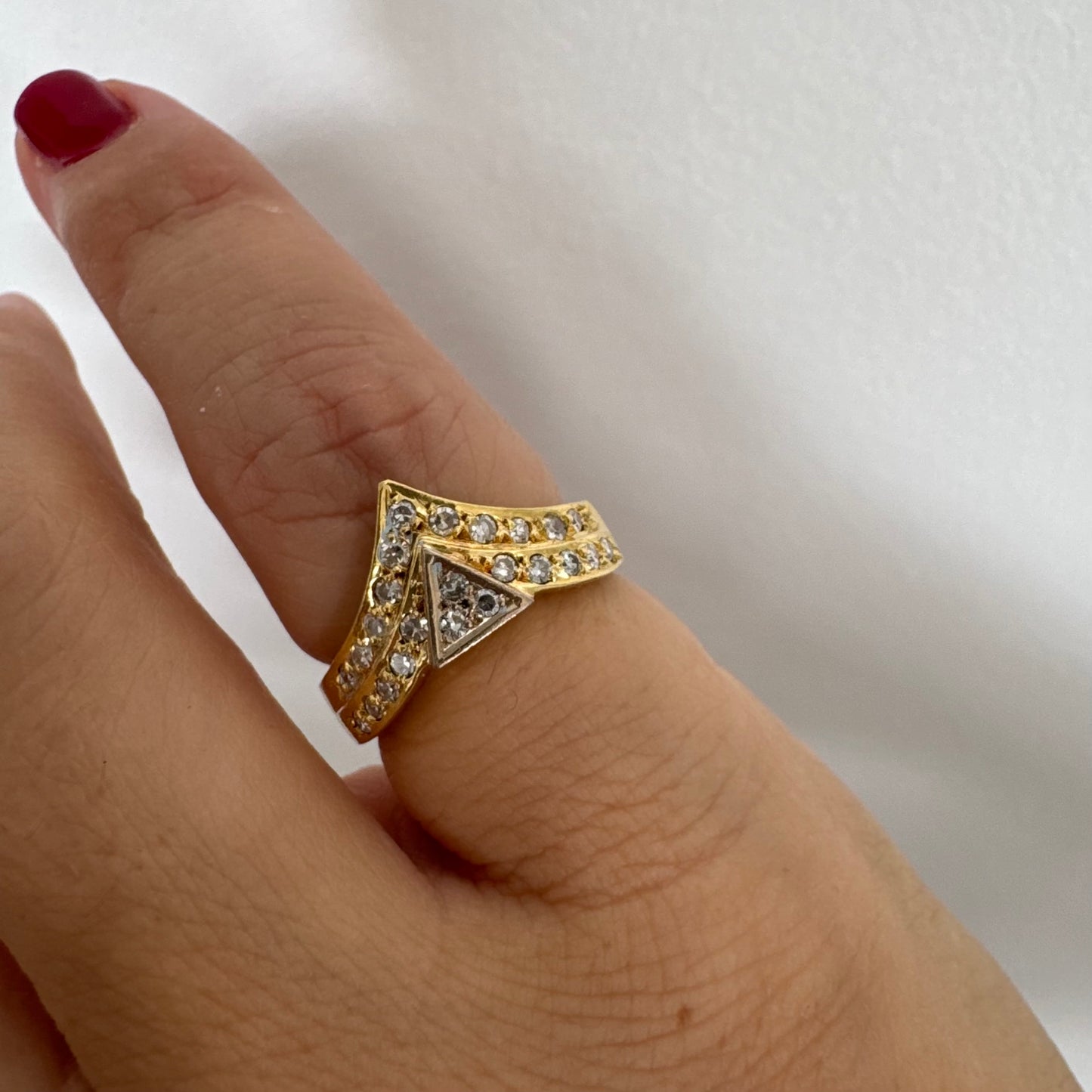 טבעת זהב צהוב 18 קראט בעיצוב גאומטרי ייחודי, משובצת יהלומים נוצצים בחיתוך עגול.