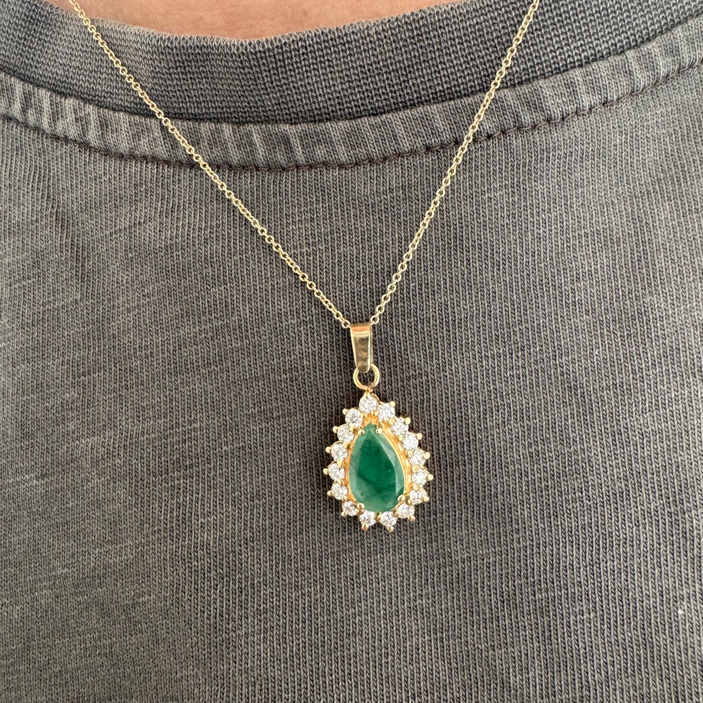 14K gold necklace set with a pear-cut Emerald, surrounded by sparkling lab-grown Diamonds.