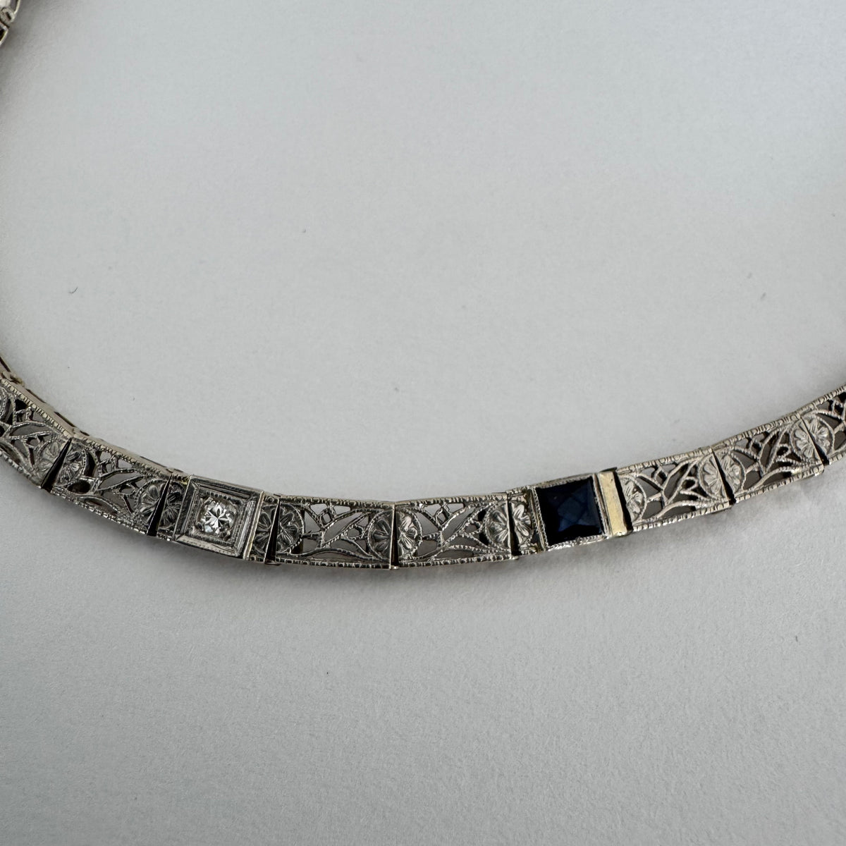 14K gold bracelet featuring intricate openwork and beautifully engraved details set with Sapphire & Diamonds