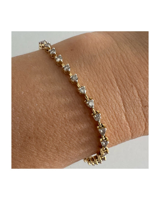 צמיד טניס עדין מזהב 14 קראט, משובץ יהלומים עגולים בשיבוץ קלאסי היוצר שורה זוהרת ואלגנטית על פרק היד.