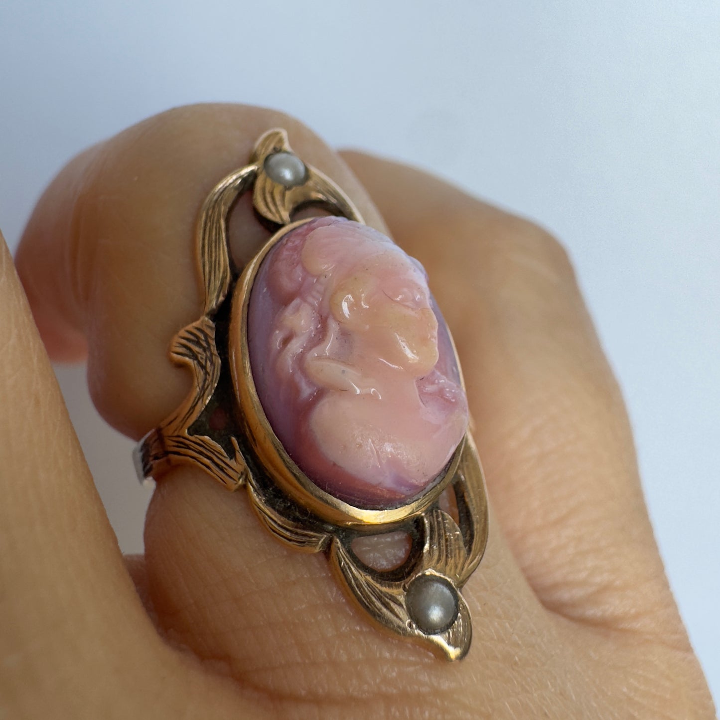 14K gold ring set with a hand-carved pink Cameo, framed by delicate details and accented with small Pearls.