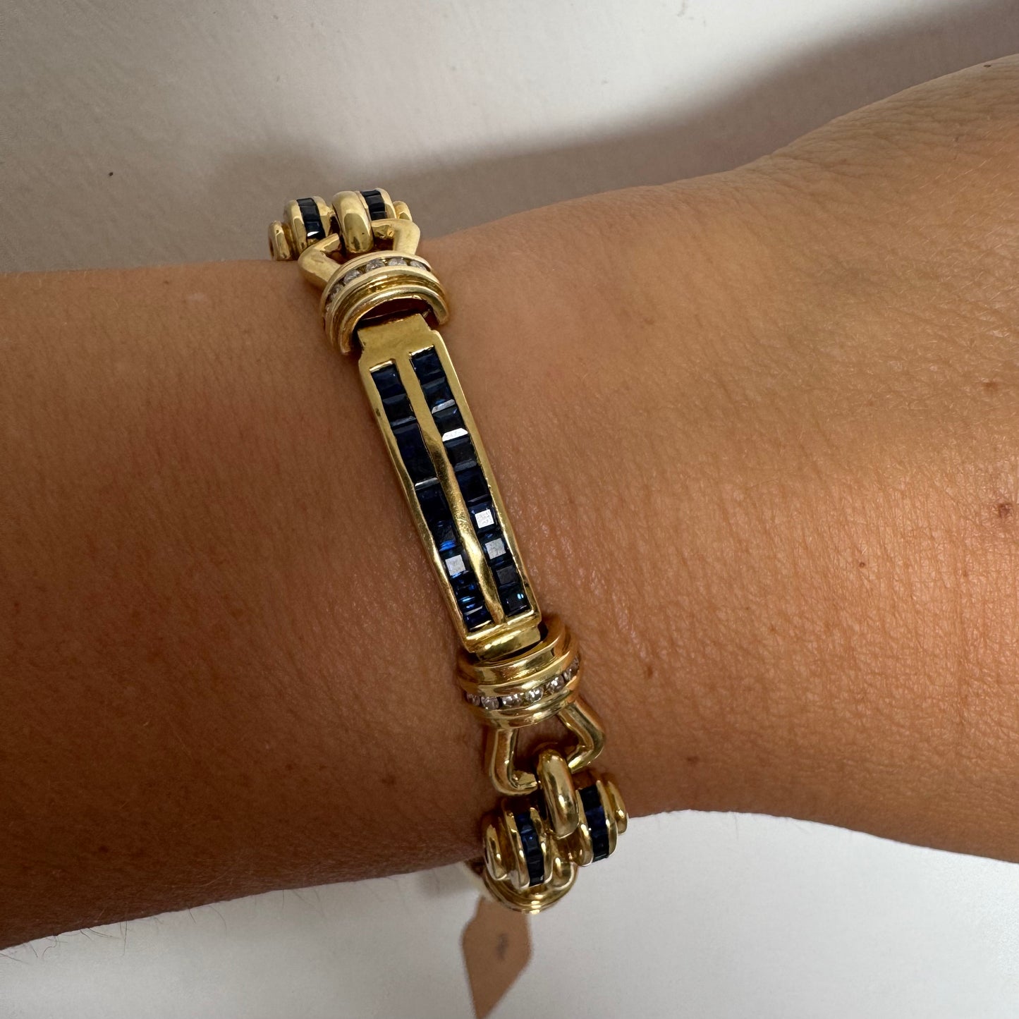 18K gold bracelet featuring a bold link design set with deep blue Sapphires and a subtle Diamond accent at the center.