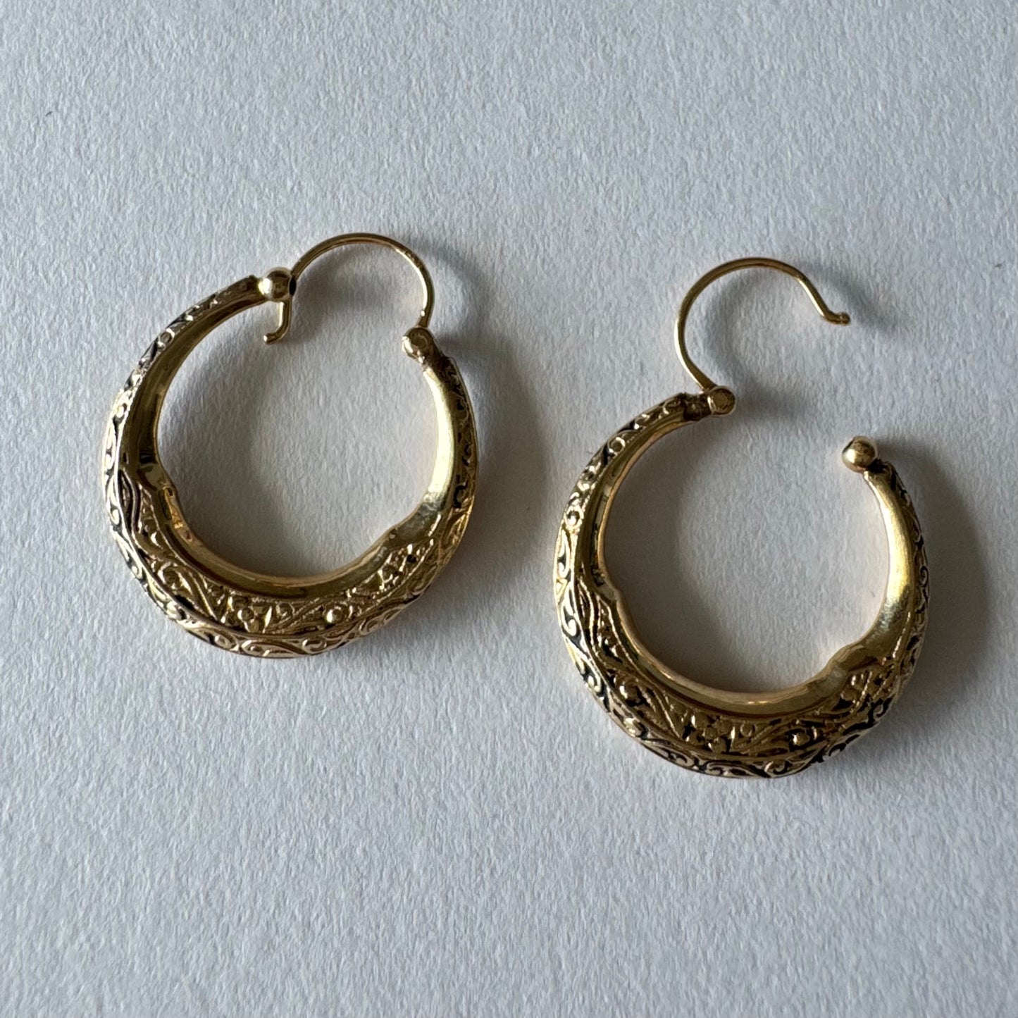14K gold hoop earrings featuring an intricate openwork design and beautifully detailed engraving