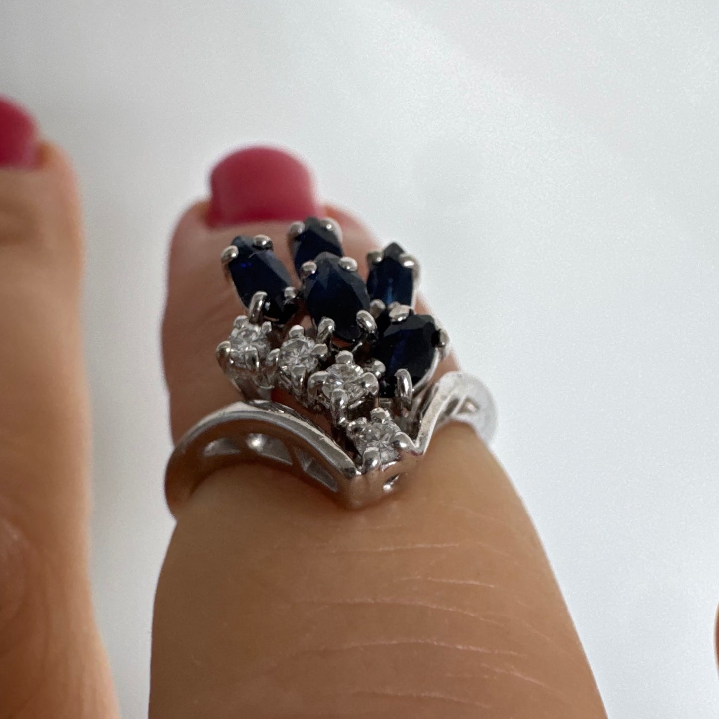 טבעת זהב לבן 14 קראט משובצת אבני ספיר כחולות בחיתוך מרקיזה ויהלומים, היוצרים מראה אלגנטי ודינמי.