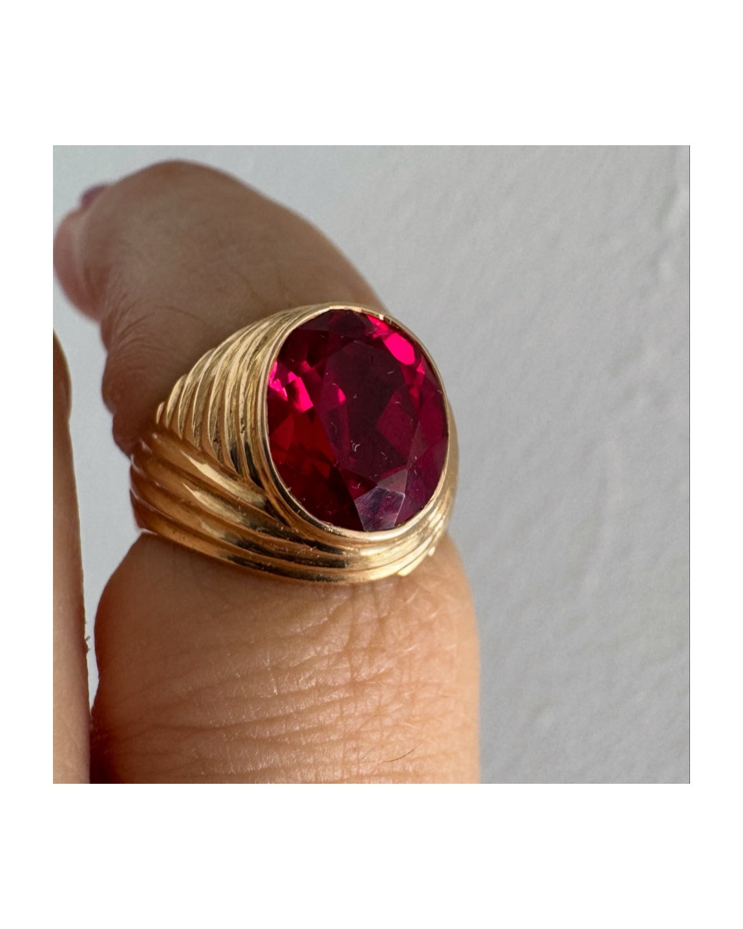 18K gold ring set with a striking oval-cut Ruby gemstone.