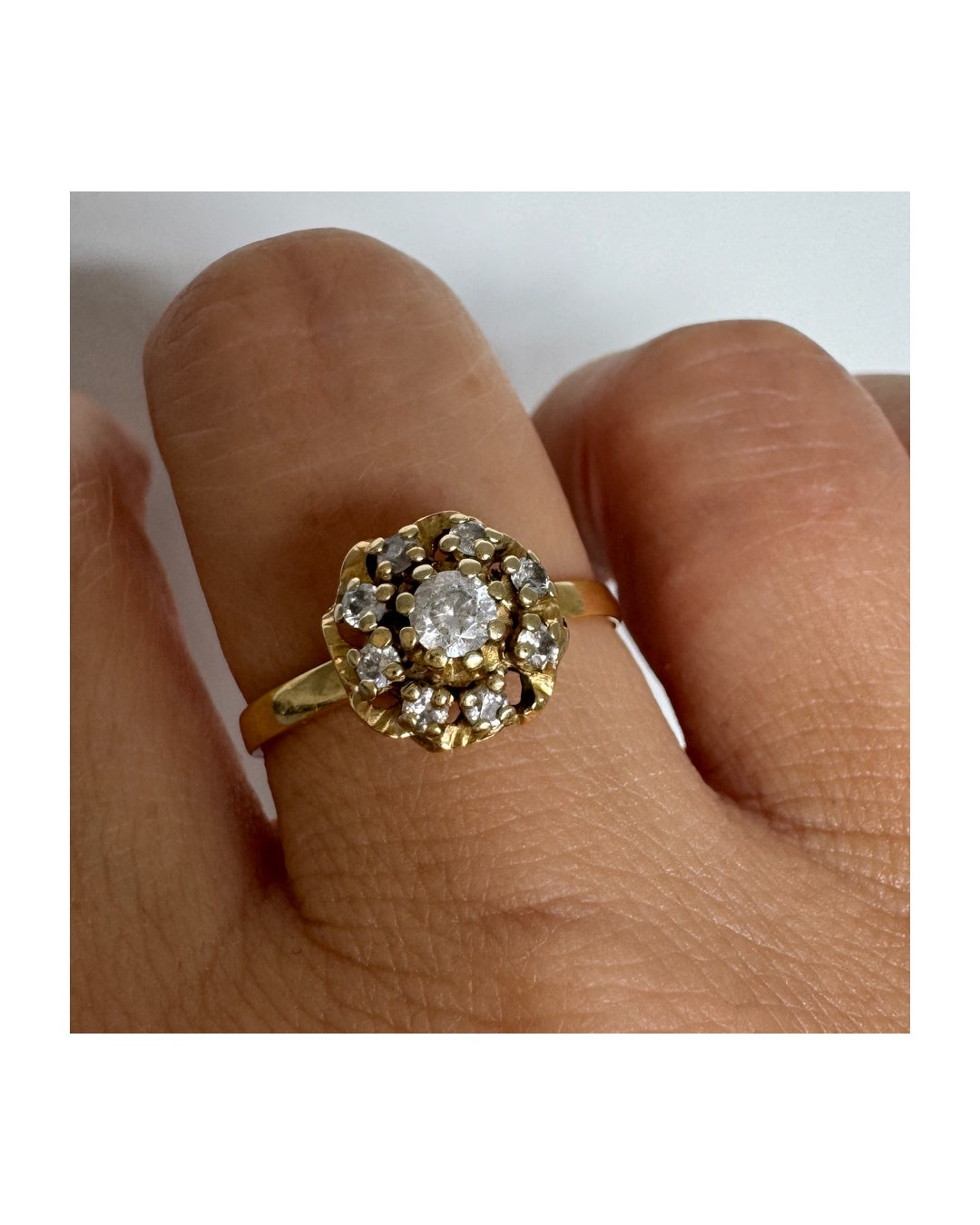 18K gold ring set with sparkling clear gemstones in a delicate floral cluster design.