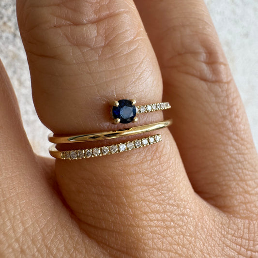טבעת זהב צהוב 14 קראט משובצת אבן ספיר כחולה ויהלומים נוצצים בשורות עדינות.