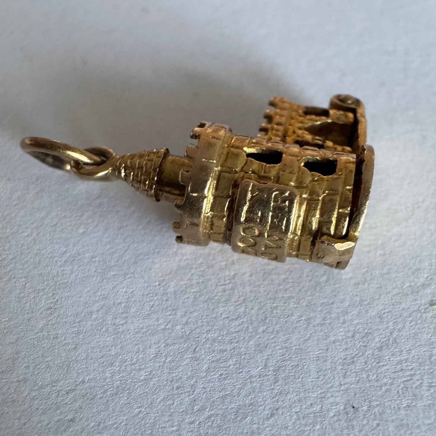 תליון זהב 9 קראט נדיר וייחודי, המהווה העתק פיסולי מפורט של ה-Bloody Tower (המגדל העקוב מדם) המפורסם ממצודת לונדון. התליון מעוצב בתלת-ממד (3D) עם טקסטורת לבנים מפורטת, צריחים, וחריטה של שם המגדל בגבו.