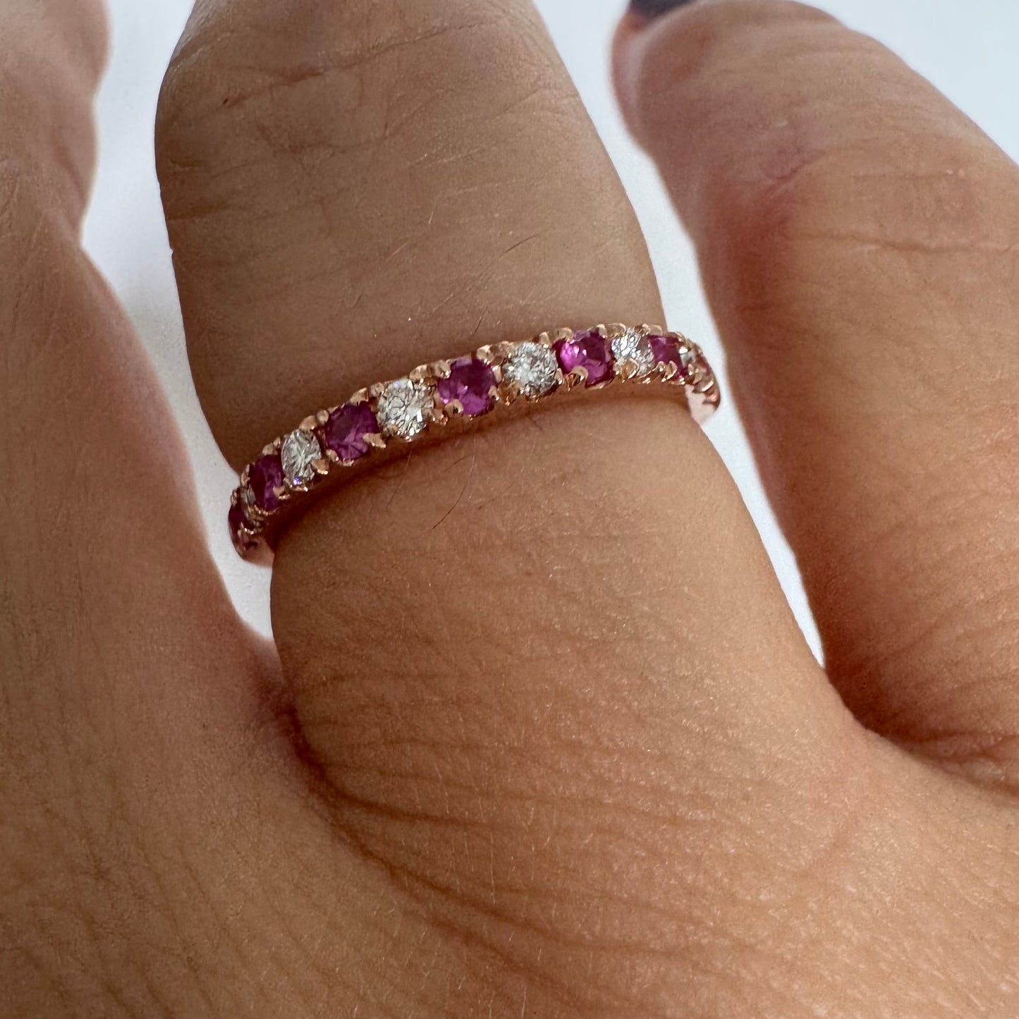 טבעת חצי איטרניטי מזהב אדום 14 קראט, משובצת ברצף של אבני רובי ויהלומים .