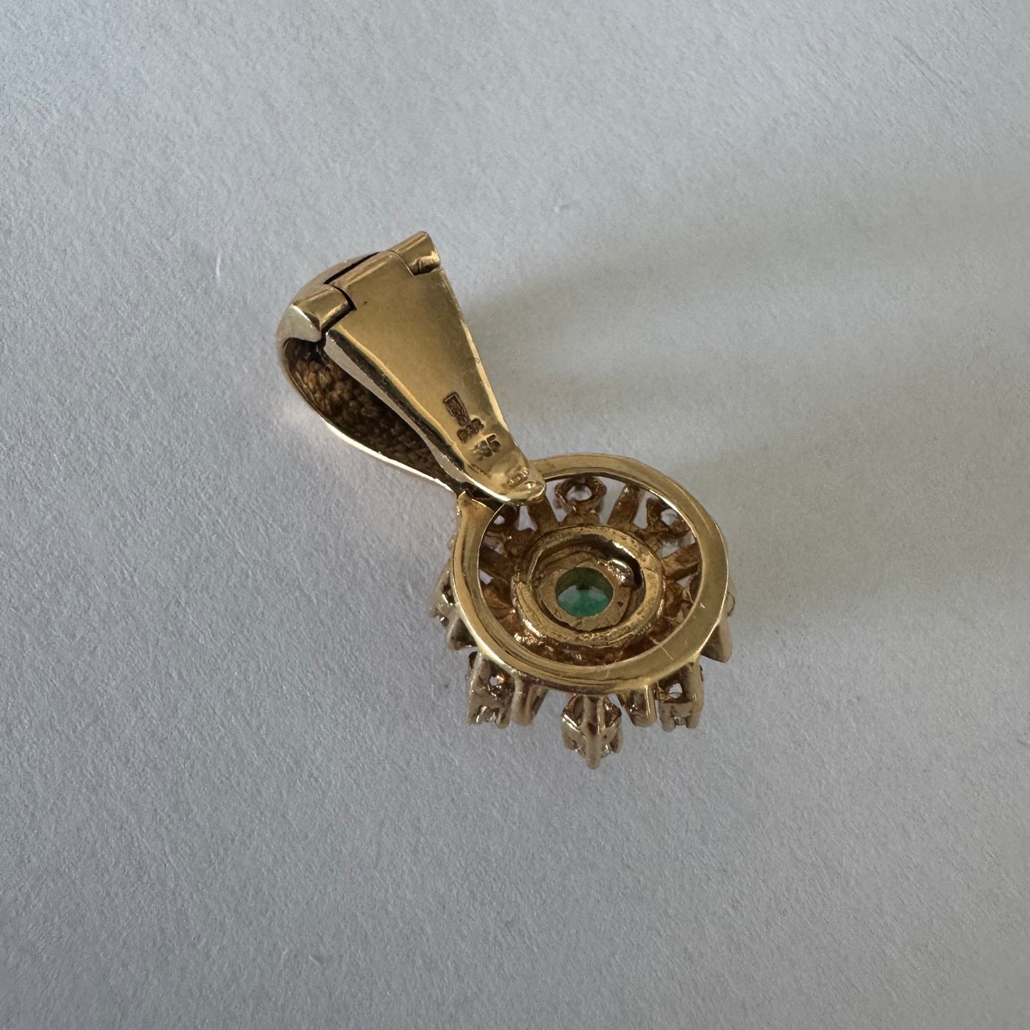 14K gold pendant centered with a Emerald and surrounded by a halo of sparkling Diamonds