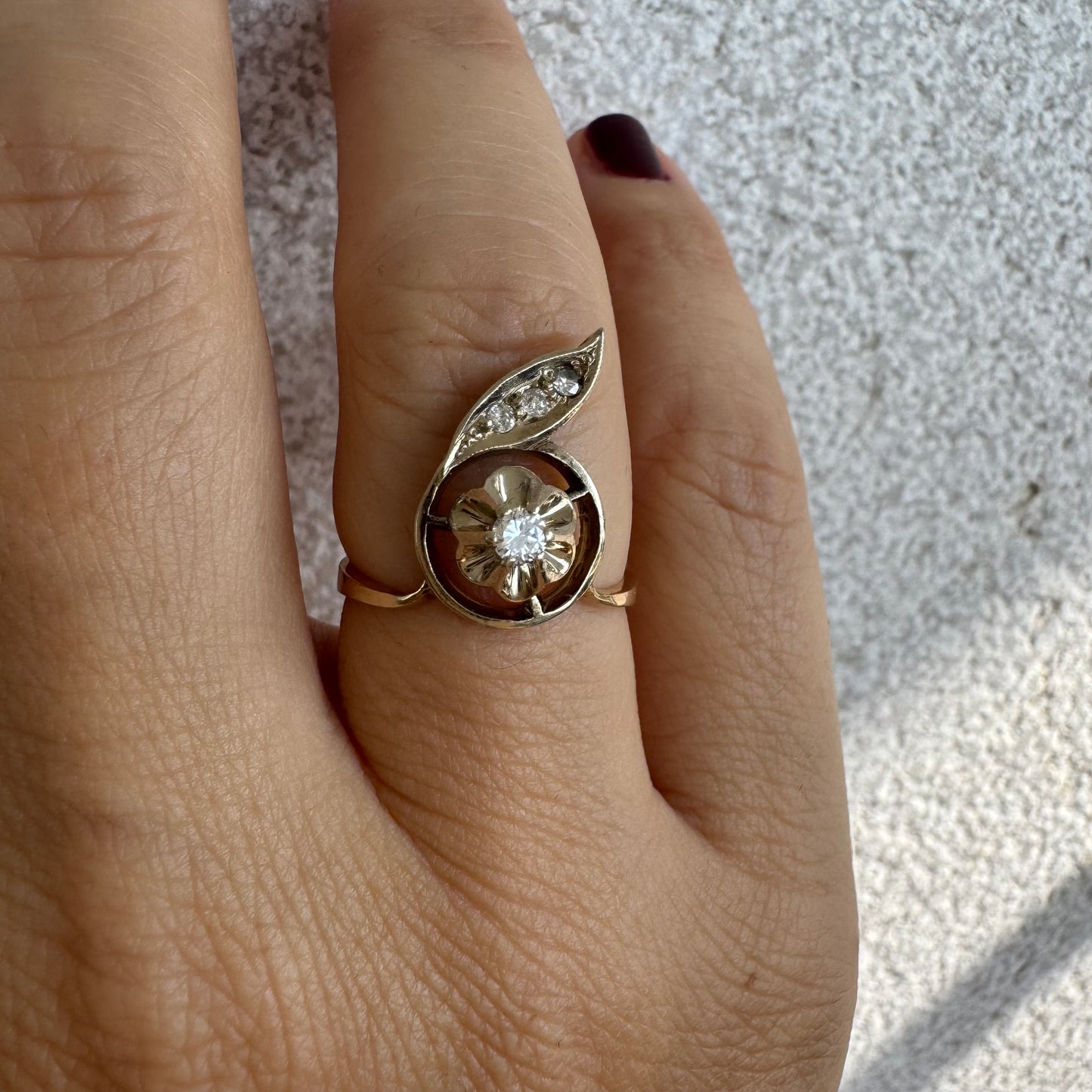 טבעת זהב צהוב 14 קראט בעיצוב פרח עדין המשובצת יהלומים נוצצים .