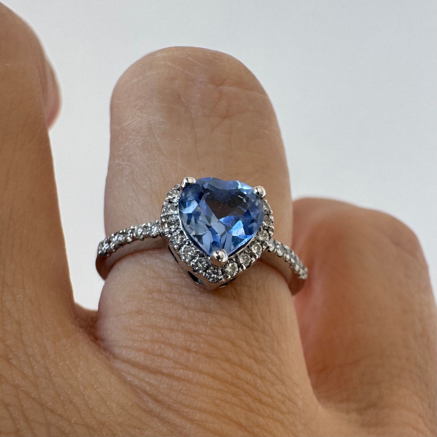 14K gold ring set with a heart-cut Tanzanite surrounded by a halo of Diamonds