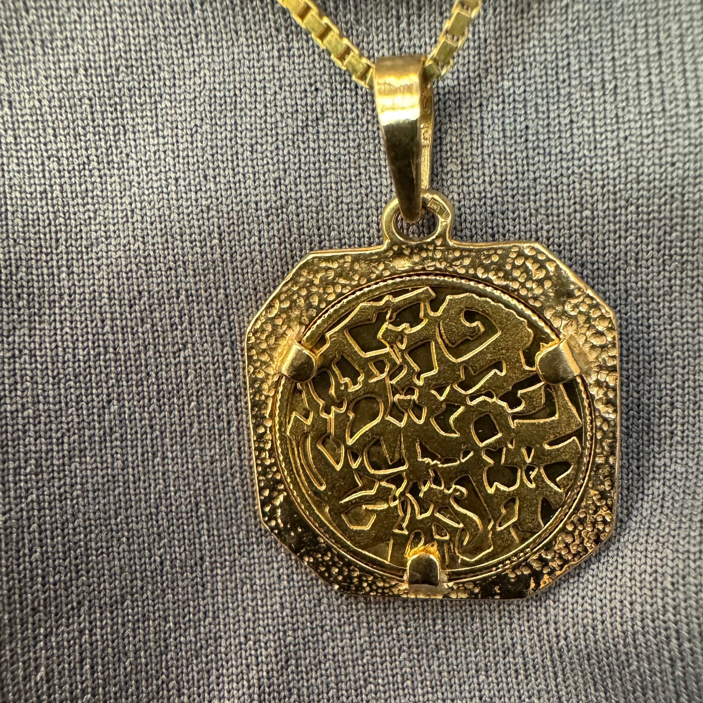 תליון זהב צהוב 14 קראט בעיצוב קלאסי עם נוכחות סמלית חזקה. במרכז התליון חריטה עדינה של עץ חיים, סמל לצמיחה, חיבור ושפע וכיתוב ״שמע ישראל״ ובצד השני אותיות ה-א״ב.