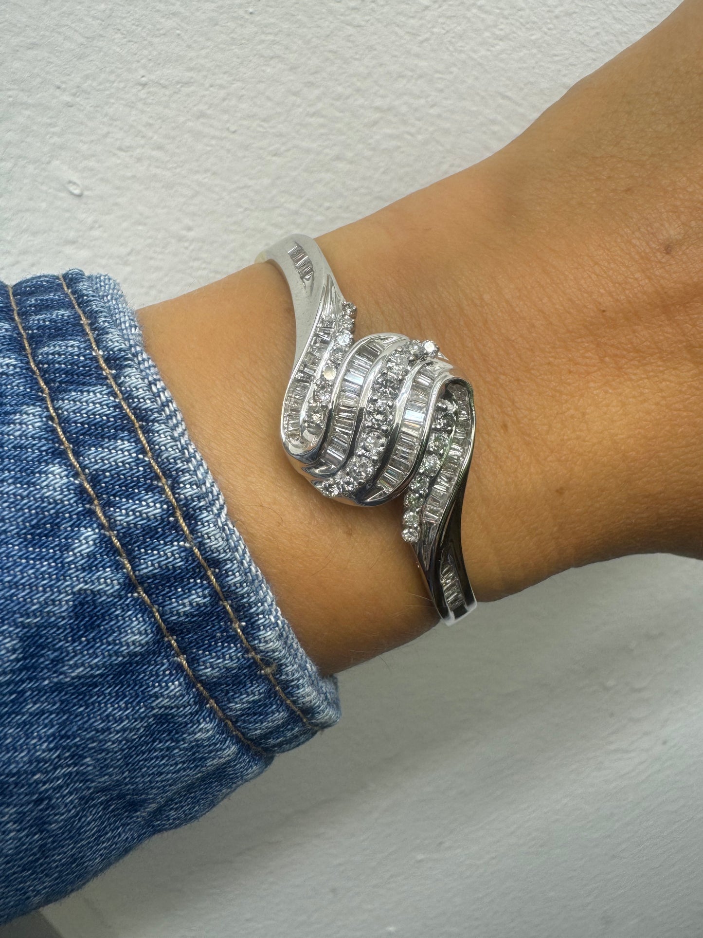 14K gold Hard bracelet featuring a flowing wave design, set with a dazzling mix of round and baguette-cut Diamonds