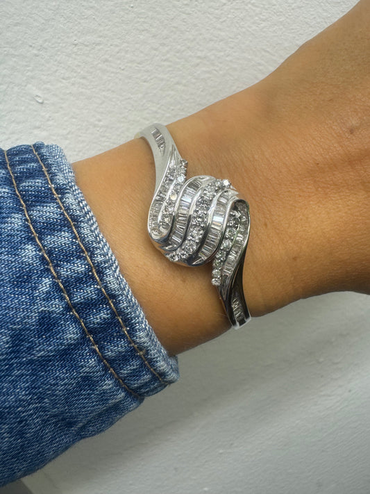 14K gold Hard bracelet featuring a flowing wave design, set with a dazzling mix of round and baguette-cut Diamonds