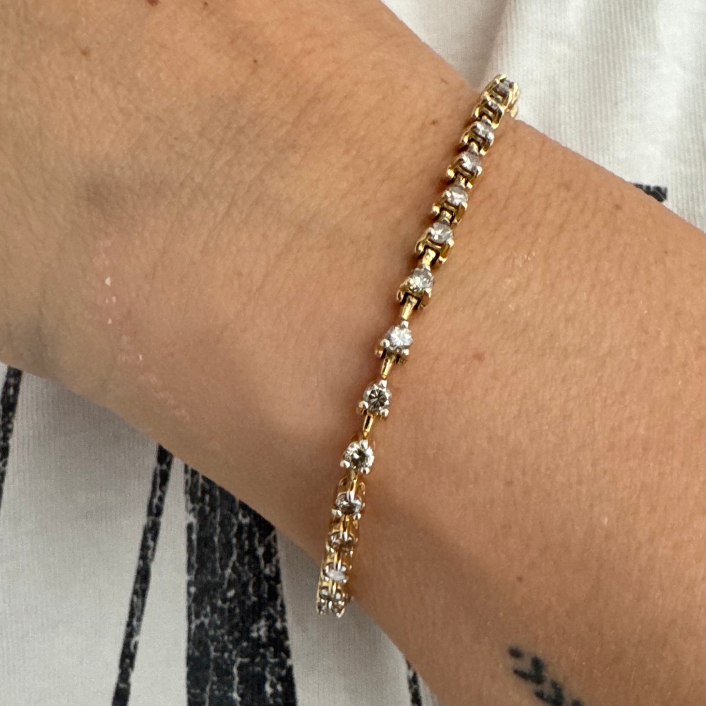 צמיד טניס מזהב צהוב 14 קראט משובץ שורת יהלומים, היוצרים ברק רציף ומראה נקי ועל-זמני.