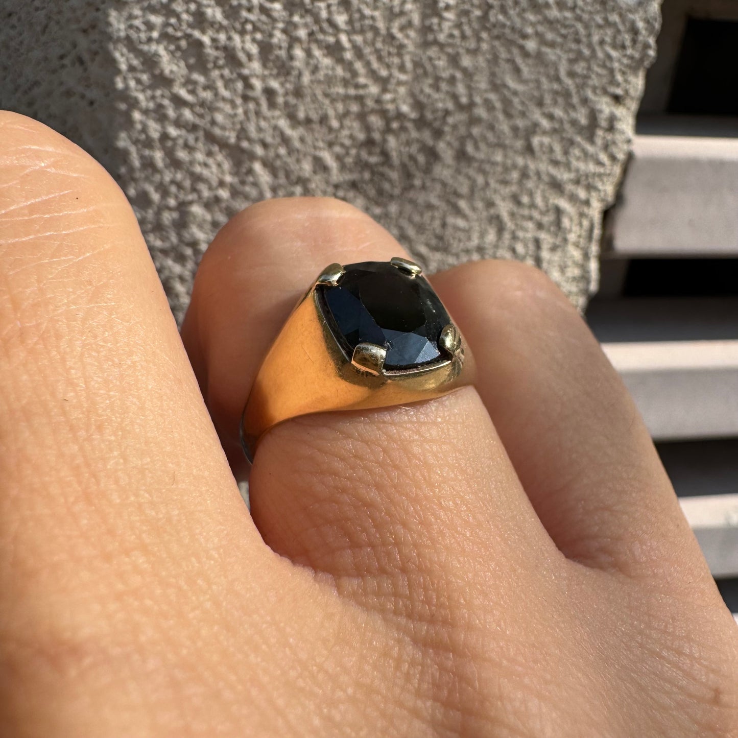 טבעת זהב 9 קראט משובצת ספיר ירוק כהה בחיתוך כרית ובתפסים עבים, בעיצוב נקי ובעל נוכחות. 