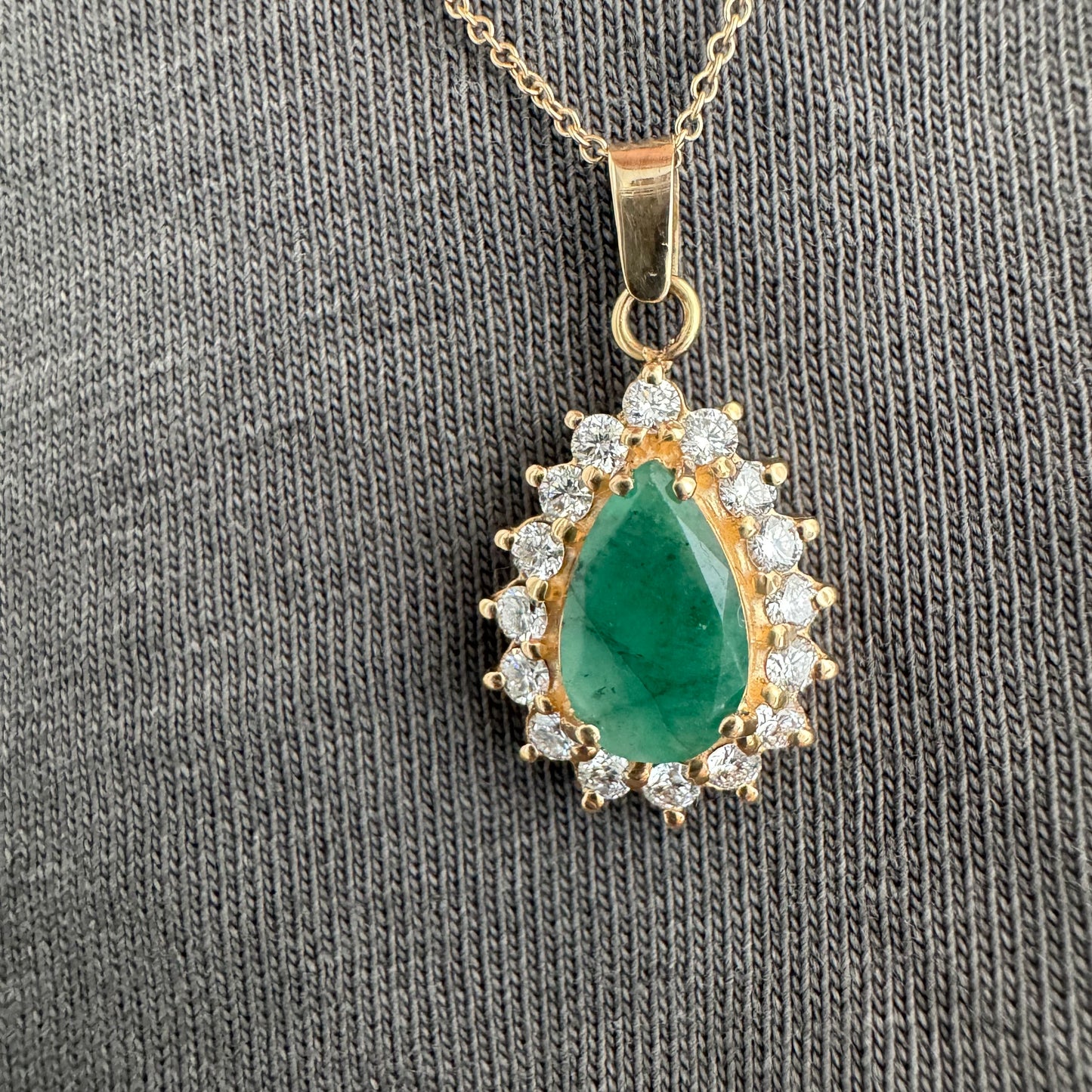 14K gold necklace set with a pear-cut Emerald, surrounded by sparkling lab-grown Diamonds.