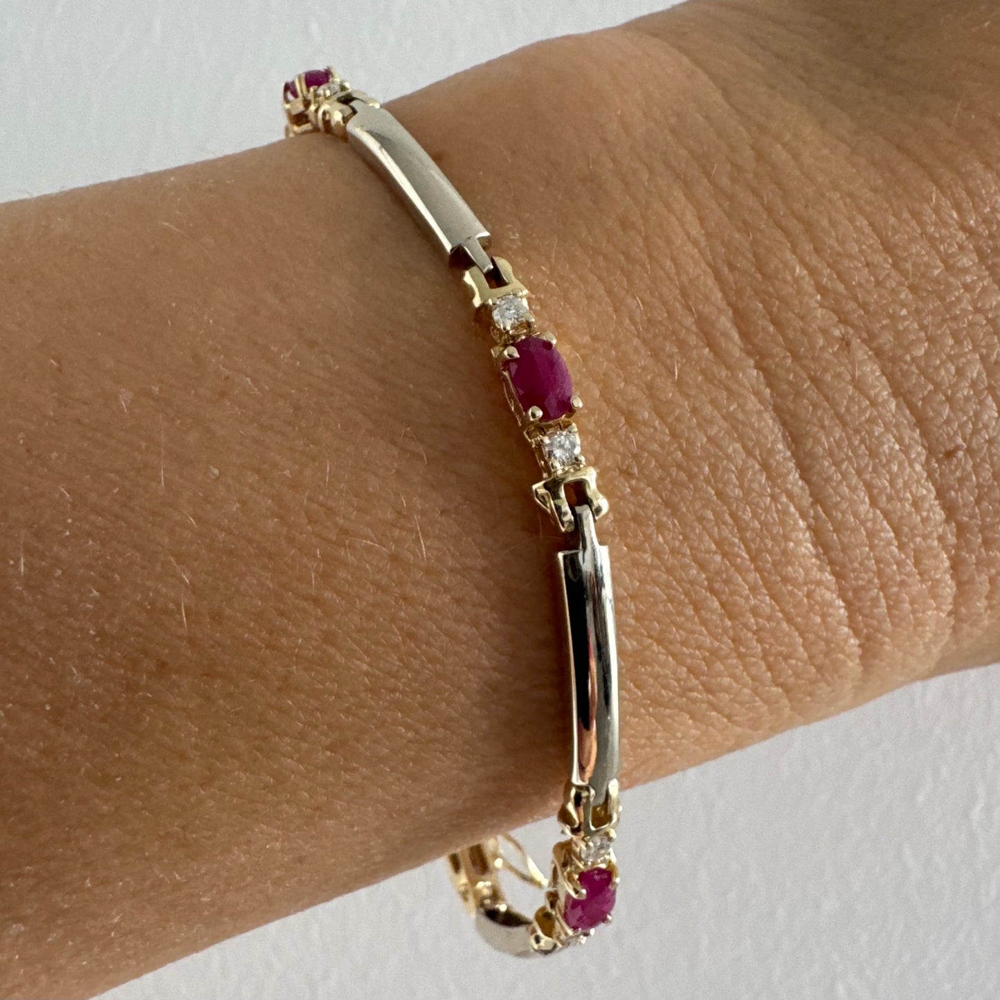 צמיד זהב צהוב 14 קראט משובץ אבני רובי אדומות בחיתוך אובלי, עם יהלומים המשובצים ביניהן להוספת ברק עדין.