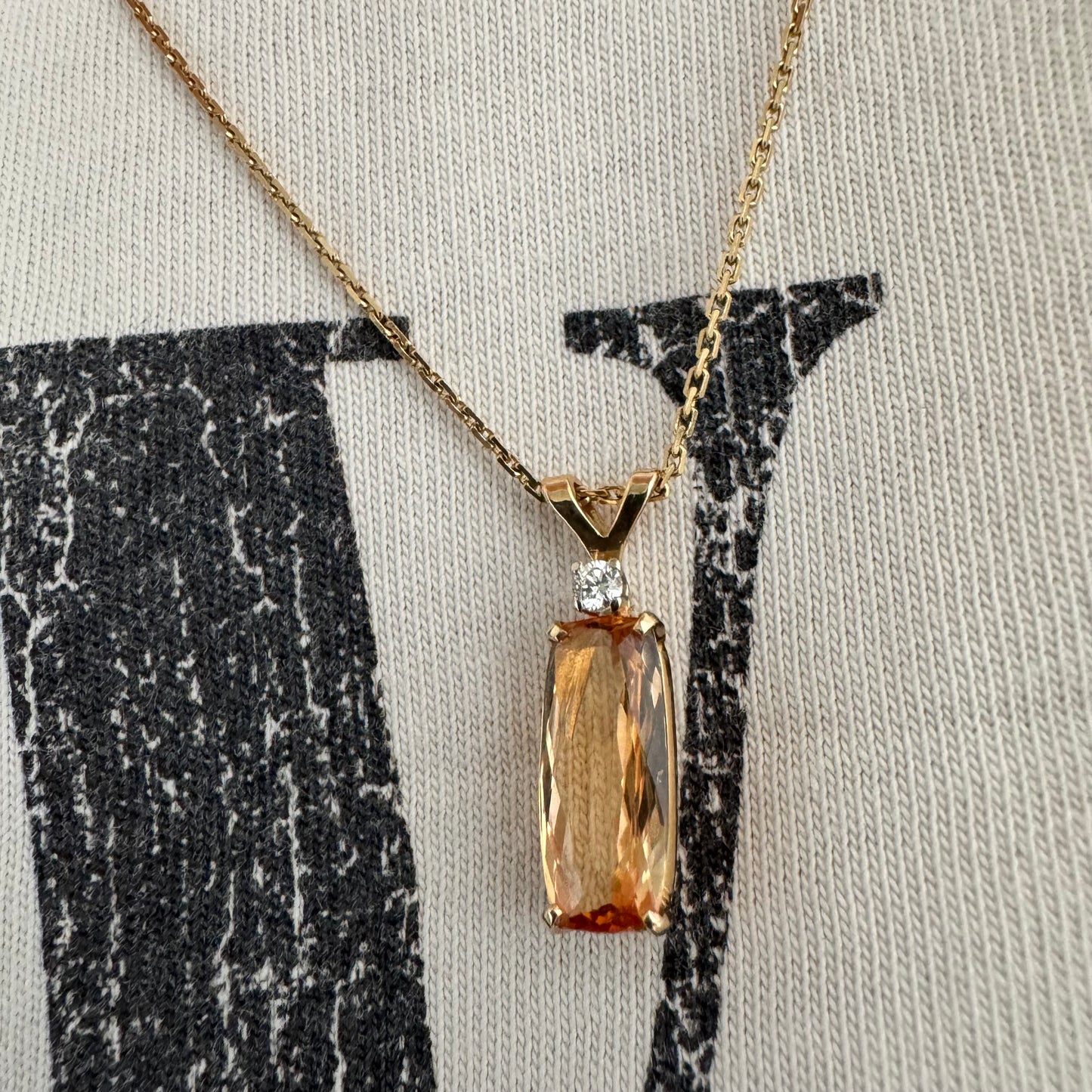 שרשרת זהב 14 קראט עם תליון זהב 14 קראט משובץ אבן קוורץ מלבנית בגוון שמפניה חמים, ומעליה יהלום נוצץ להדגשה עדינה של הברק.