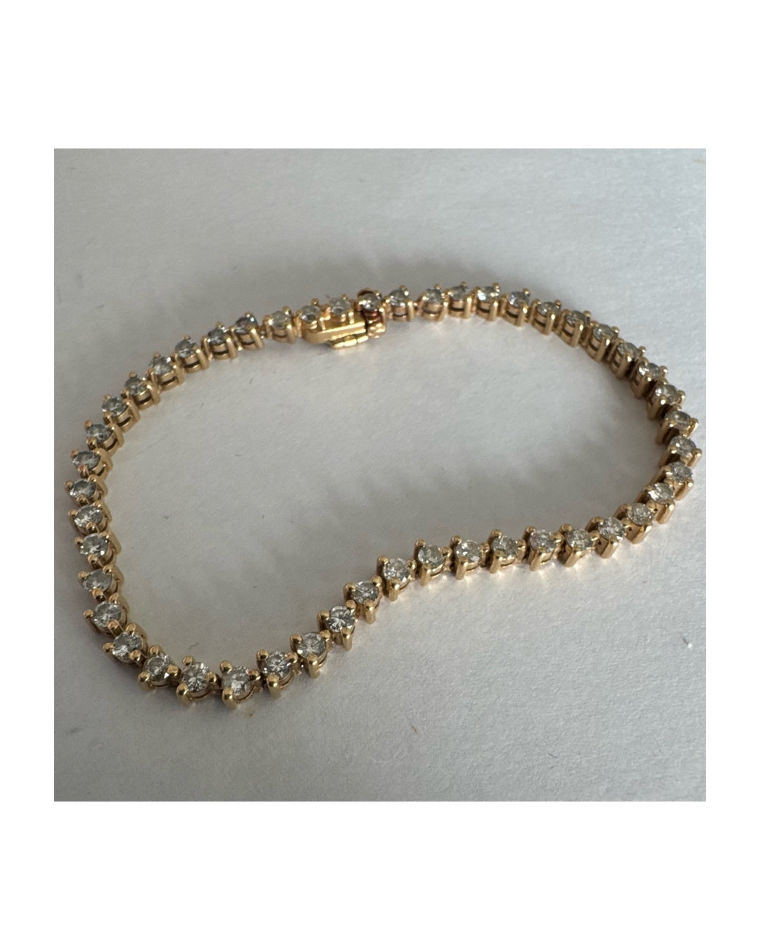 14K gold tennis bracelet set with a continuous line of round Diamonds, creating a delicate and elegant sparkle.