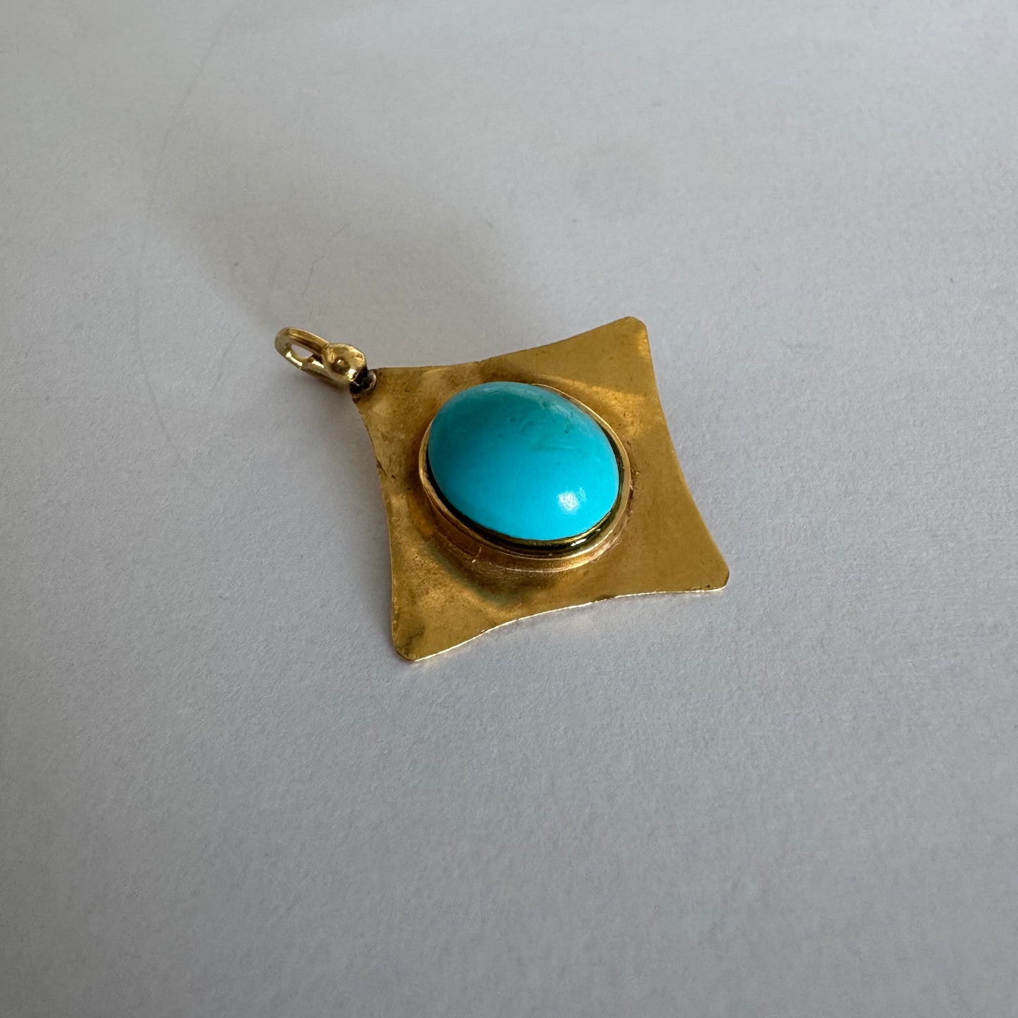 18K gold pendant set with a vibrant Turquoise stone in a bold, geometric design.