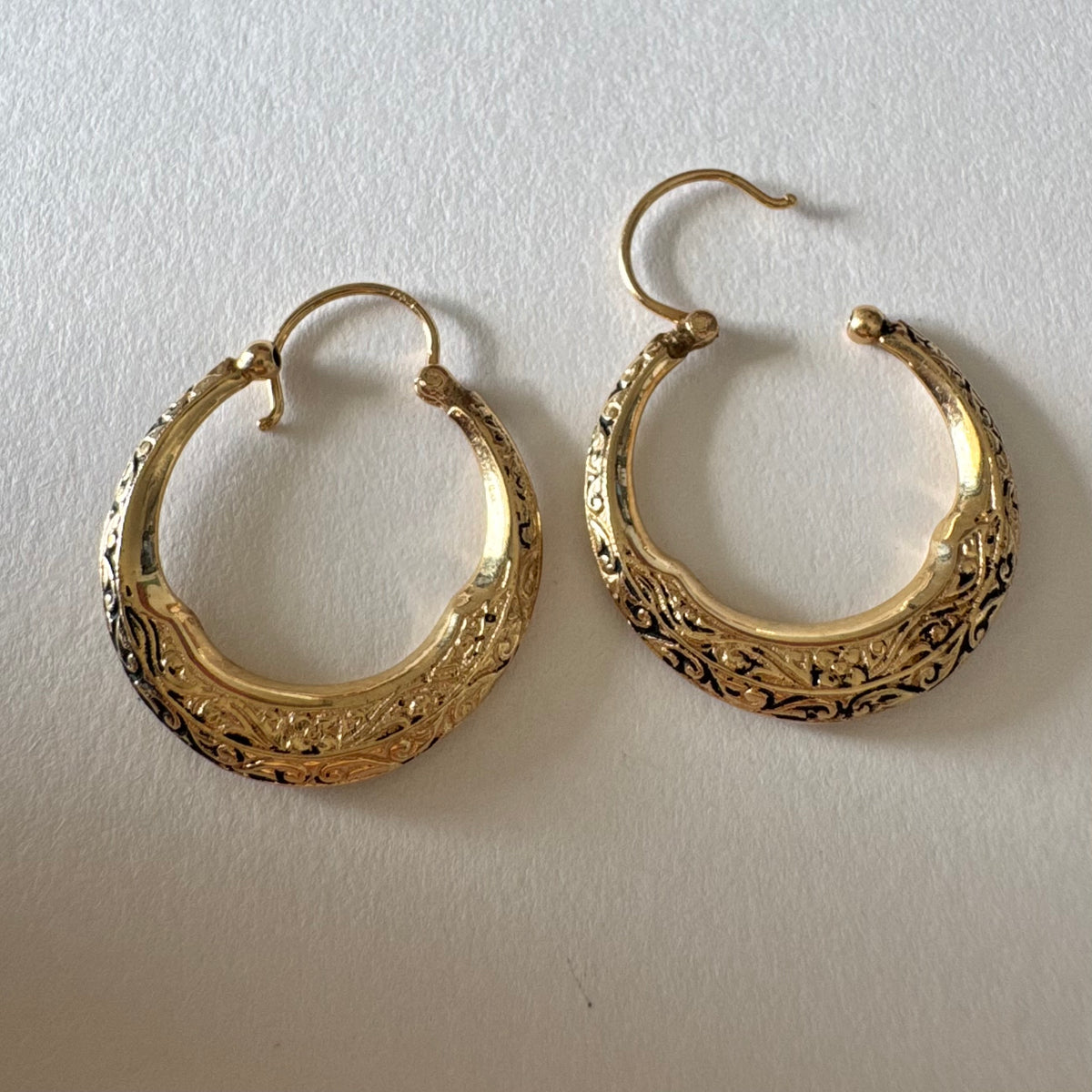 14K gold hoop earrings featuring an intricate openwork design and beautifully detailed engraving