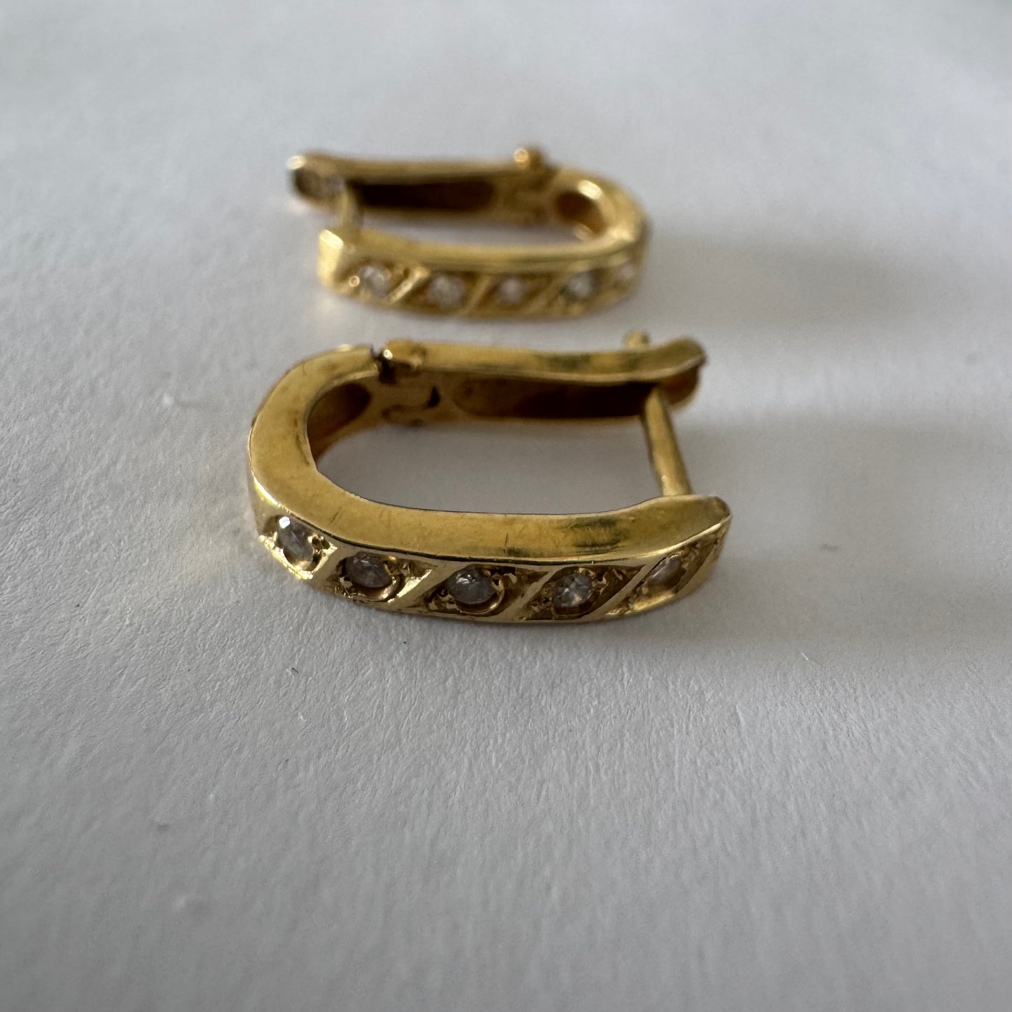 14K gold huggie earrings accented with a delicate row of sparkling Diamonds